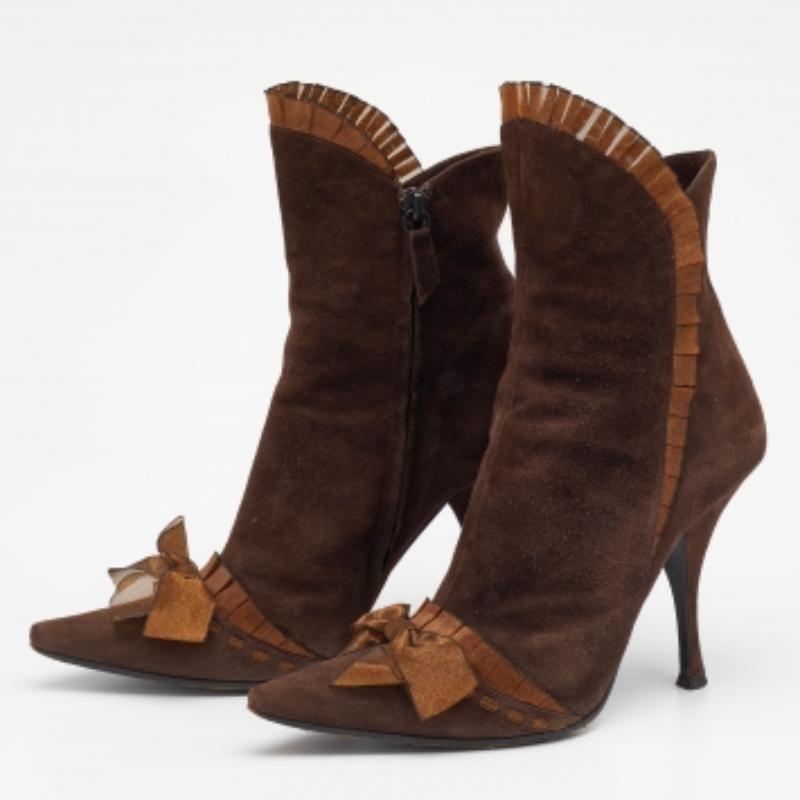 Donnez une touche chic à votre tenue avec cette paire de bottines Casadei. La création est parfaitement cousue à l'aide de daim et agrémentée d'accents de nœuds, de bordures à volants et de talons de 10,5 cm. Faites une déclaration avec ça !