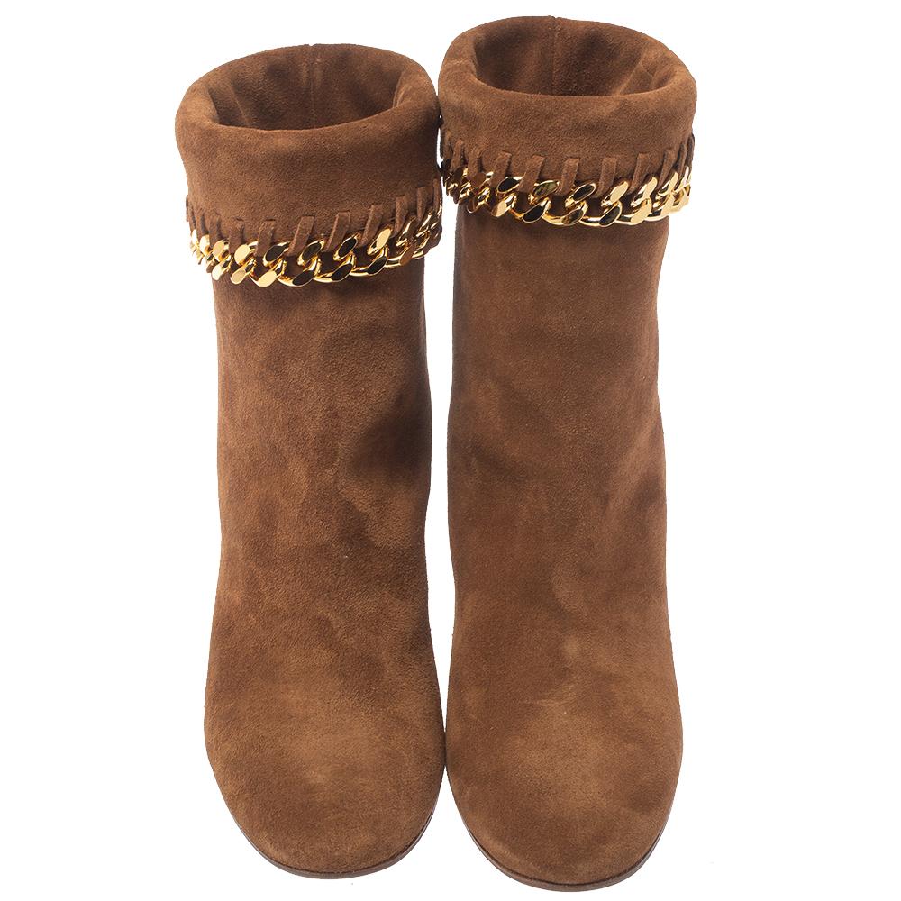 These classic Renna boots from the house of Casadei are fashioned in a chic brown suede body and detailed with gold-tone chain trim at the opening. They are set on a comfortable, low-lying block heel and completed with an almond-shaped toe. It comes
