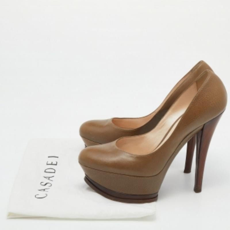 Perfila un look sofisticado con estos elegantes zapatos de salón de Casadei. Están diseñadas con piel de color caqui en el exterior. Estos zapatos tienen un tacón de 13,5 cm, plataforma y son deslizables. ¡Luce un aspecto estupendo al caminar con