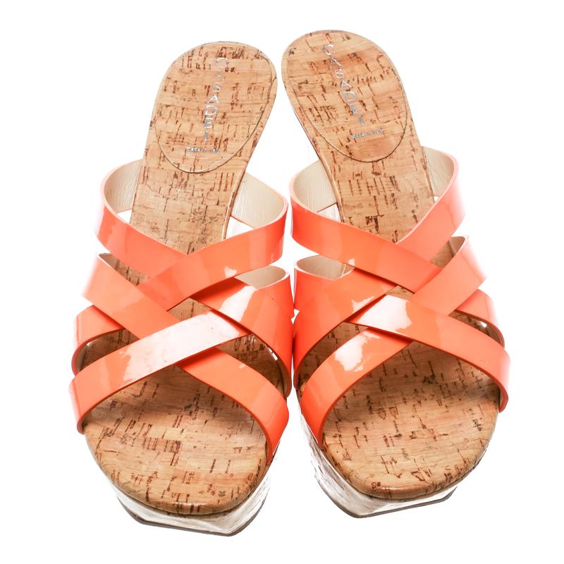 Let your feet do all the talking with these stunning Casadei creations. They feature orange cross straps made from patent leather and cork wedge heels. These stylish sandals are lined with leather and will keep you at the top of your shoe