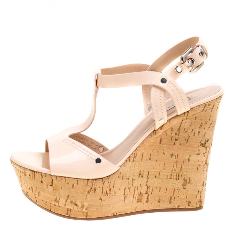 These pale pink sandals from Casadei are ultra feminine and spell unapologetic glamour. These stunning sandals are crafted from patent leather and feature an open toe silhouette. They flaunt a T-strap design on the vamps, buckled ankle straps and