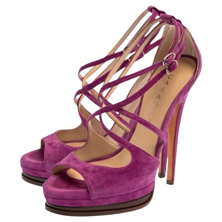 Win praises every time you step out in these sandals from Casadei! Beautifully designed with suede, they successfully present a gorgeous appeal. The purple pair carries open toes, stilettos and cross straps with ankle fastenings. The sandals are