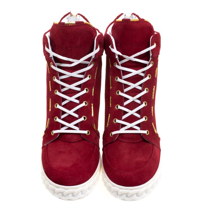 Comfy and high on style, these sneakers by Casadei have been created to be flaunted. They feature a red exterior made from suede and enhanced with piping details and laces. The pair also comes with chain details on the midsoles, concealed wedges,
