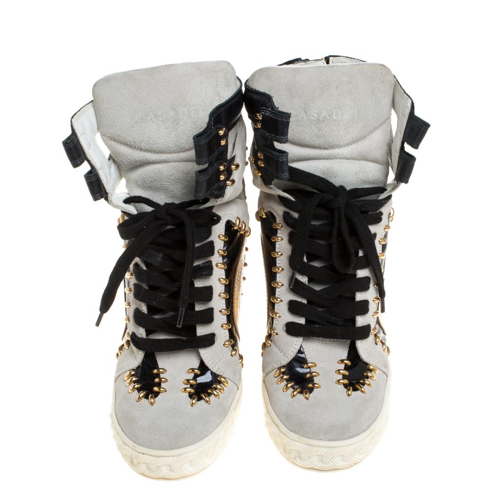 Comfy and high on style, these wedge sneakers by Casadei have been created to be flaunted. They feature a tricolor exterior made from leather, suede and patent leather and enhanced with gold-tone details and a lace-up vamp. The pair also comes with