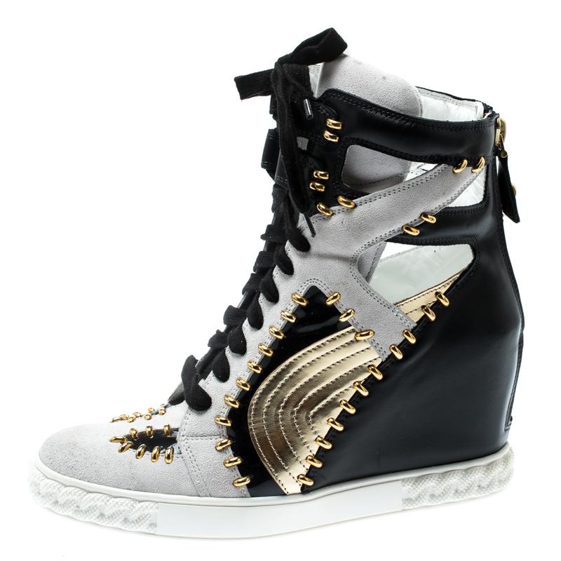 Comfy and high on style, these wedge sneakers by Casadei have been created to be flaunted. They feature a tricolor exterior made from leather, suede and patent leather and enhanced with gold-tone details and a lace-up vamp. The pair also comes with