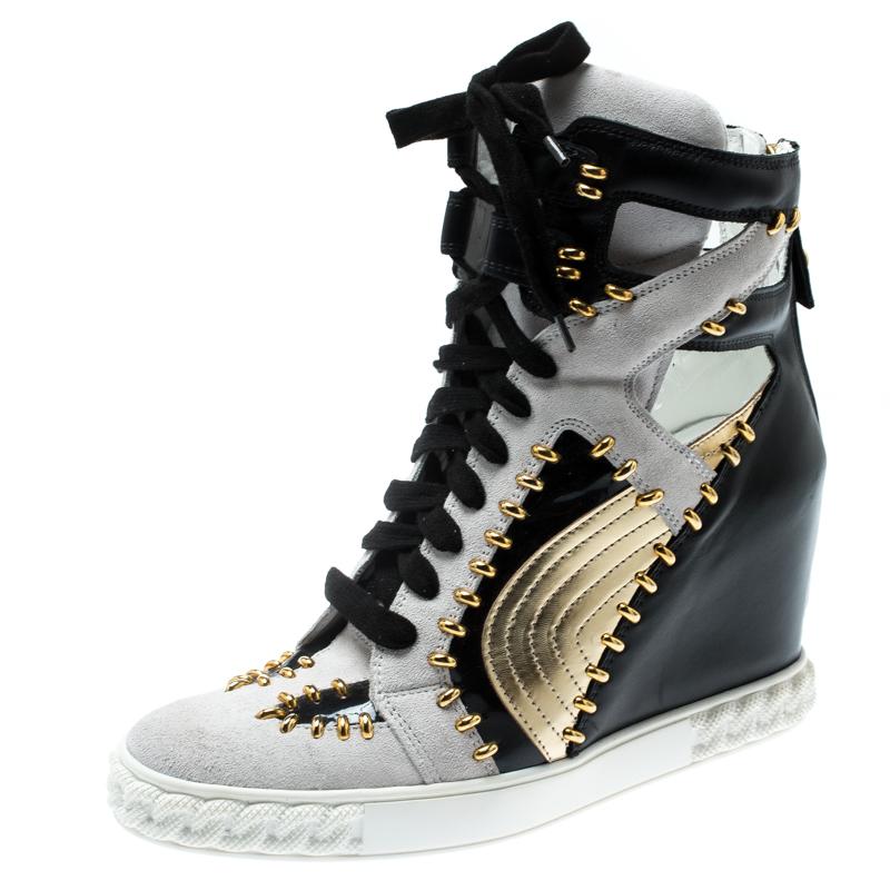 Comfy and high on style, these wedge sneakers by Casadei have been created to be flaunted. They feature a tricolor exterior made from leather, suede and patent leather and enhanced with gold-tone details and a lace-up vamp. The pair also comes with