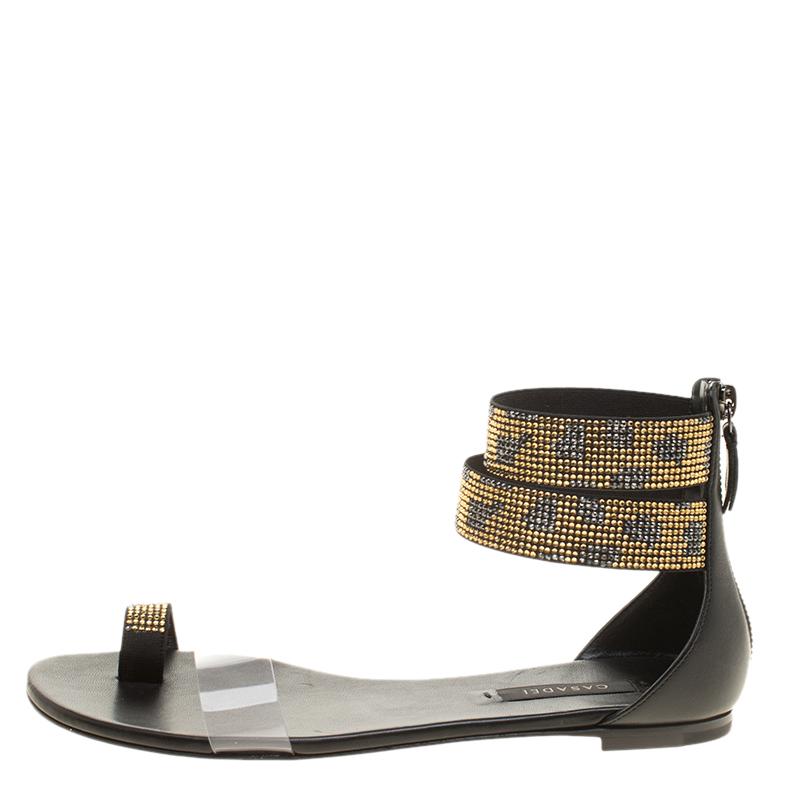A pair of flats that do not compromise on the high fashion statement for everyday comfort, the Casadei Two Tone Crystal Embellished Ankle Cuff and PVC Vinil Flat Sandals are going to soon become a favourite of yours. The gunmetal tone hardware gives