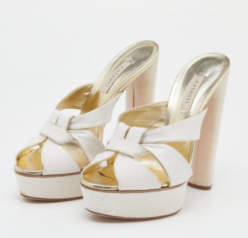 Ces magnifiques sandales de la maison Casadei sont synonymes de classe et d'élégance éternelles ! Elles sont réalisées en paille tissée blanc-or et en cuir sur l'extérieur et présentent des bouts pointus, une fonction d'enfilage et des talons blocs.