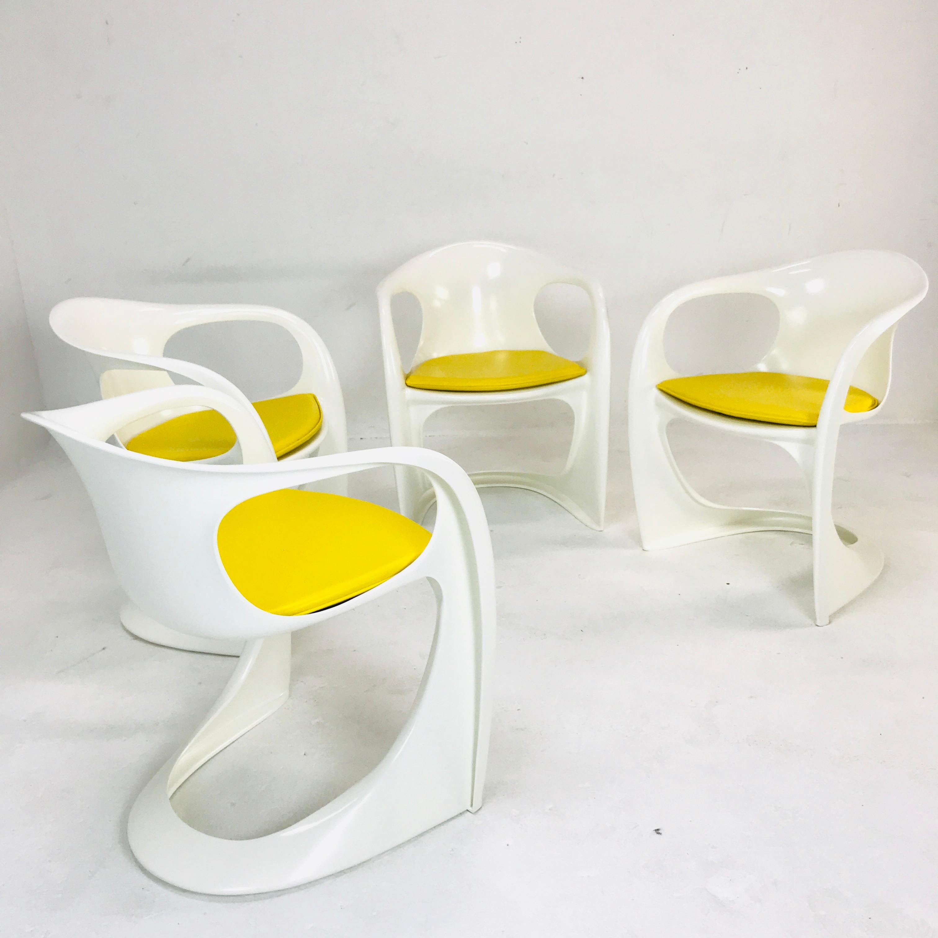 Set of 4 white Casalino chairs with yellow leather upholstery seating. By Alexander Begge.