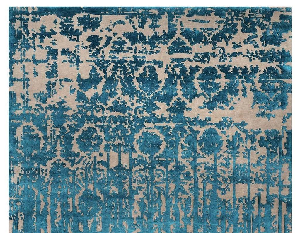 Hand knotted in Nepal by master craftsmen who have been collaborating with Illulian since 1959, the striking design of this elegant rug is a juxtaposition of textures in tons of beige and turquoise that evokes ancient luxury. Composed of 50% silk
