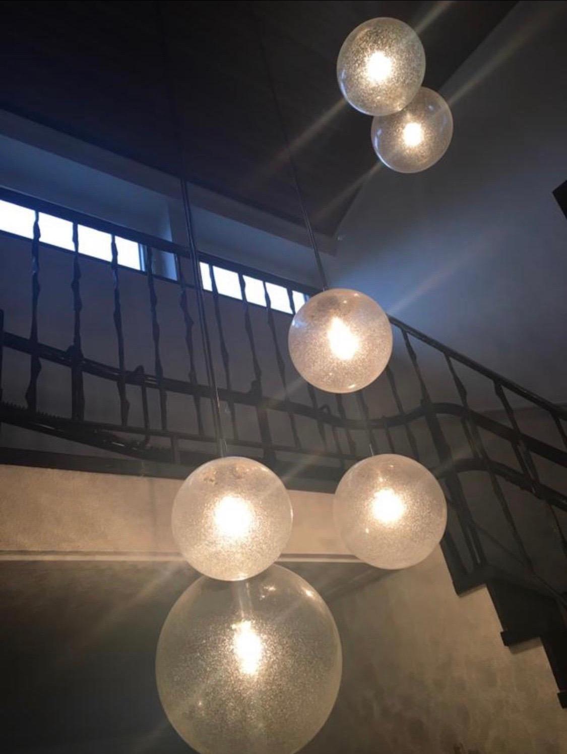 Cascade chandelier bubble glass , glass balls Kalmar/Putzler, 1960, Vienna, Austria.
Six various sized lid up glass balls with numerous tiny air bubbles in the glass lid up by a single Edison 40W bulb.
Great for a stairway or an installation for a