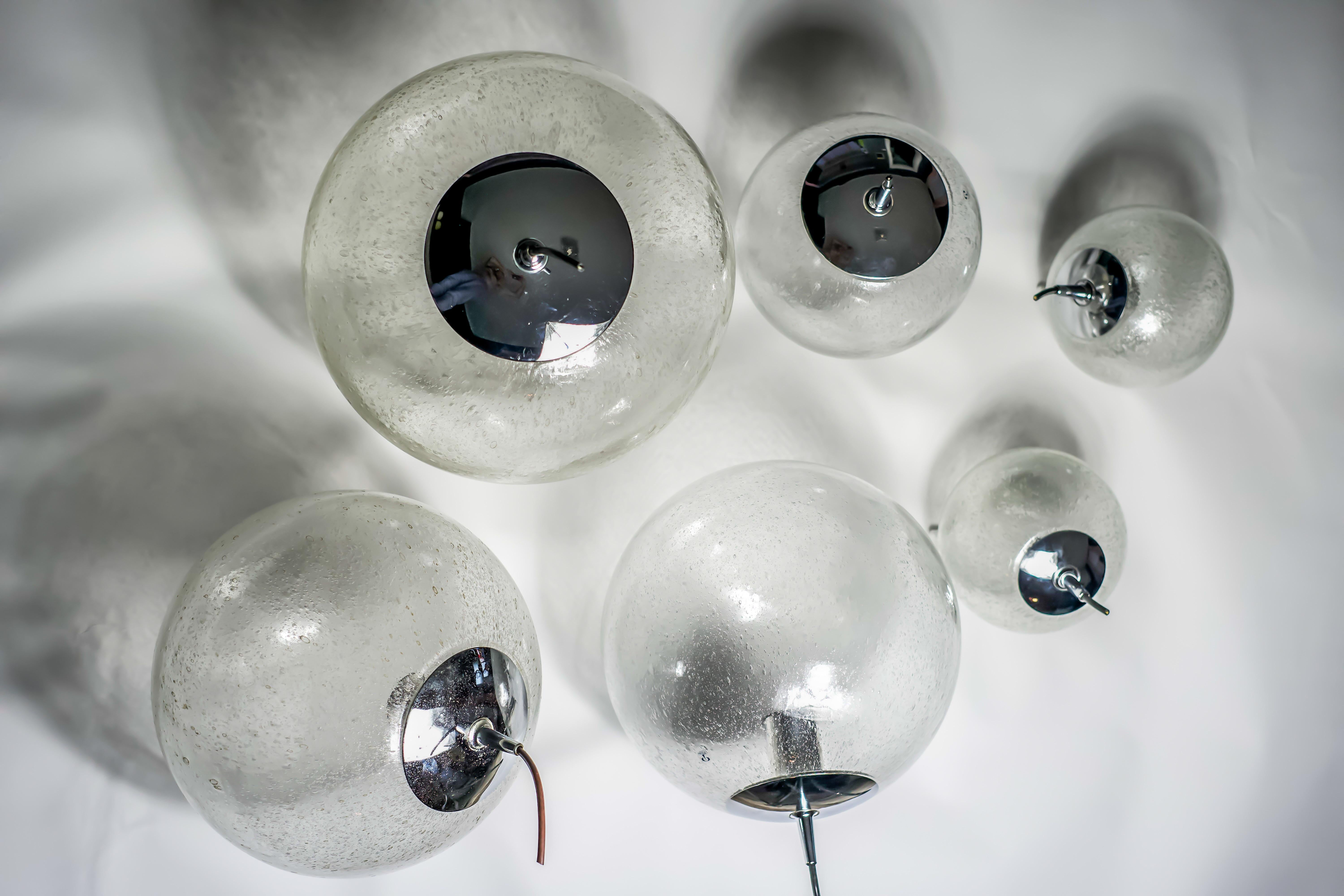 Cascade chandelier bubble glass , glass balls Kalmar/Putzler, 1960, Vienna, Austria.
Six various sized lid up glass balls with numerous tiny air bubbles in the glass lid up by a single Edison bulb.
Great for a stairway or an installation for a