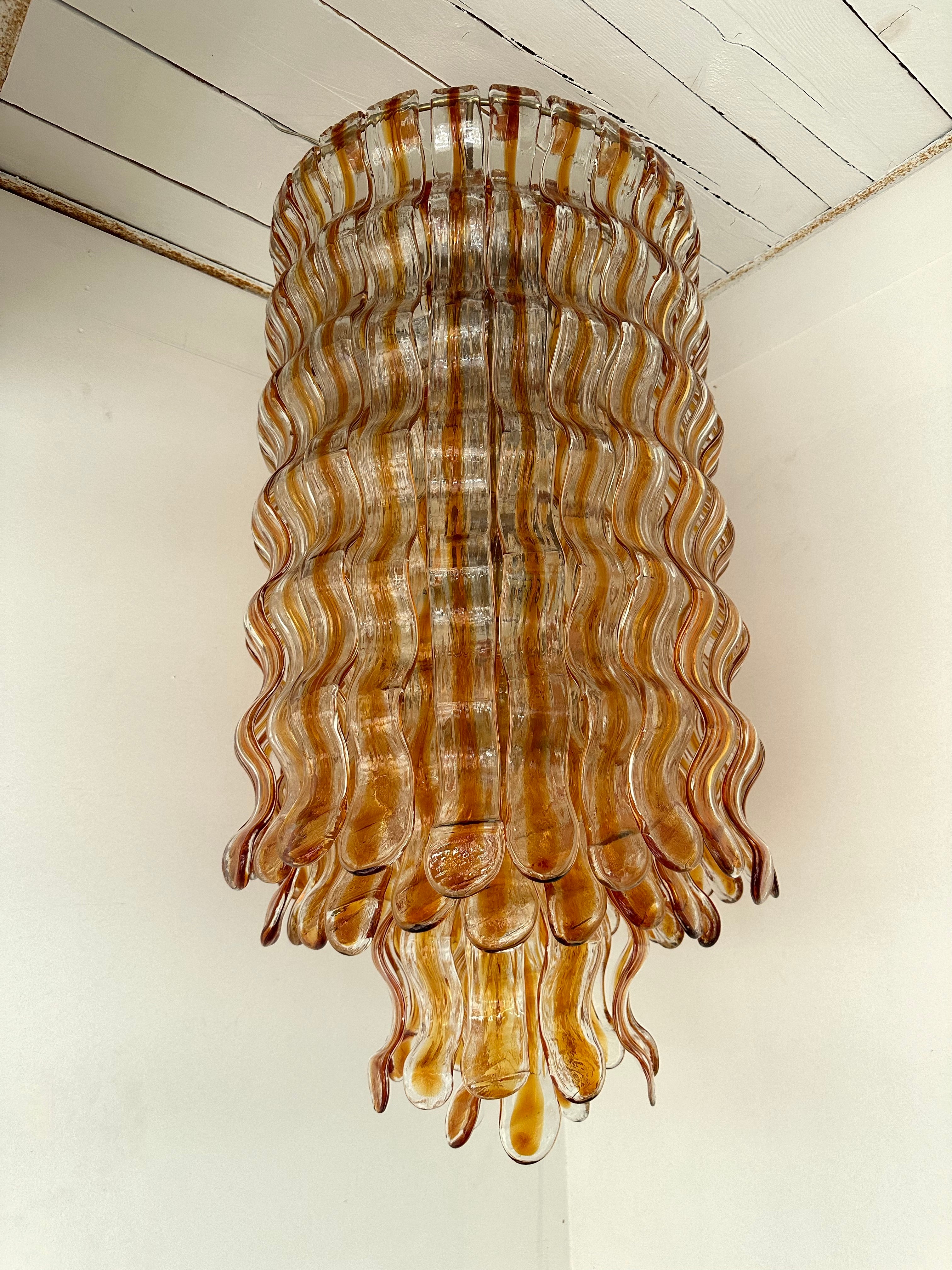 Mid-Century Modern Space Age Hollywood Regency Cascade Wave Chandelier Deckenleuchte Pendelleuchte in Bernstein klar Murano Glas und vergoldetem Metall Struktur von der Herstellung Mazzega, Design zugeschrieben Carlo Nason. Berühmte Hersteller wie