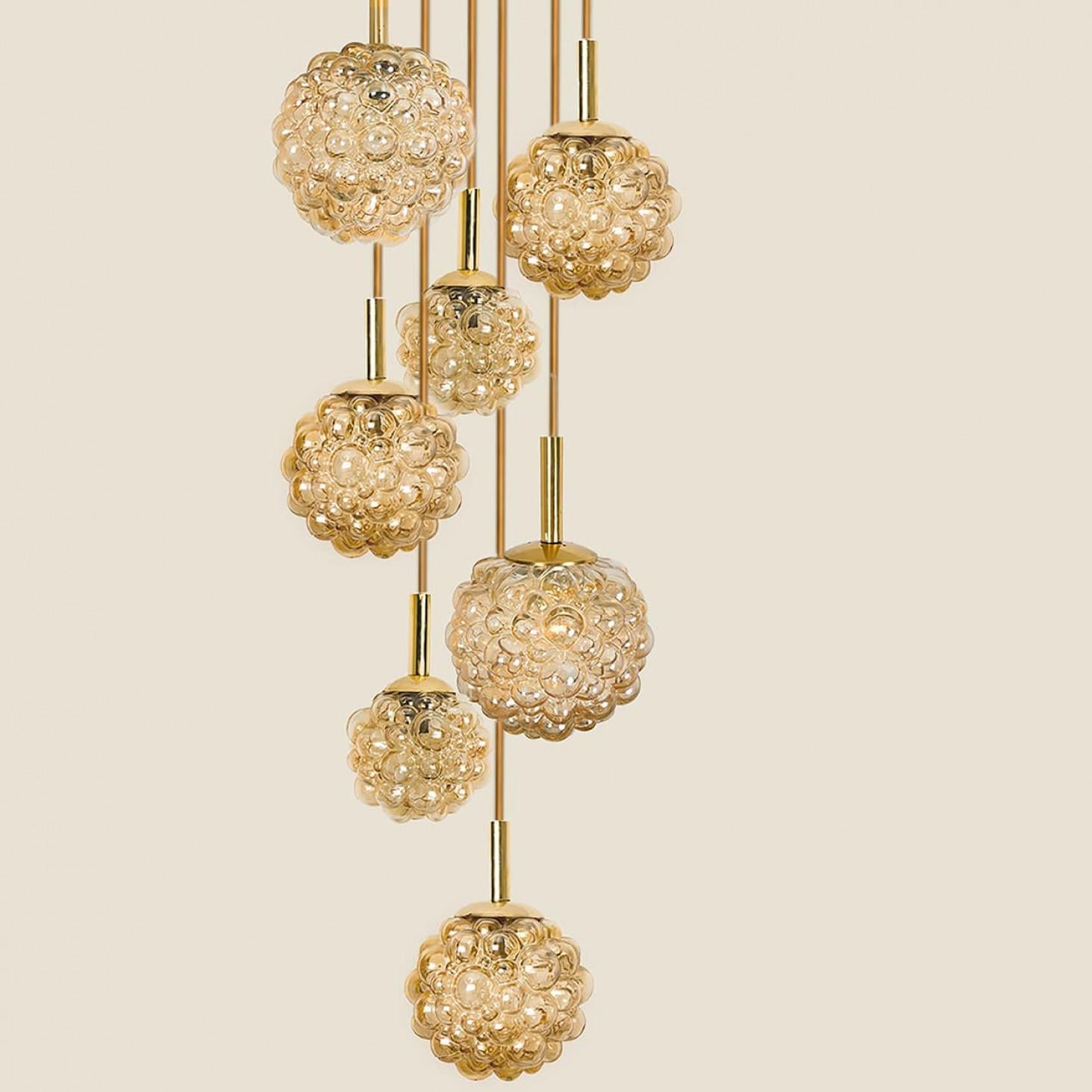 Amazing ceiling mount pendant light fixture with eight different bubbled glass globes by Helena Tynell, manufacturered around the 1970s.

High-end handblown amber glass which creates a stunning illumination in every interior.

A unique statement