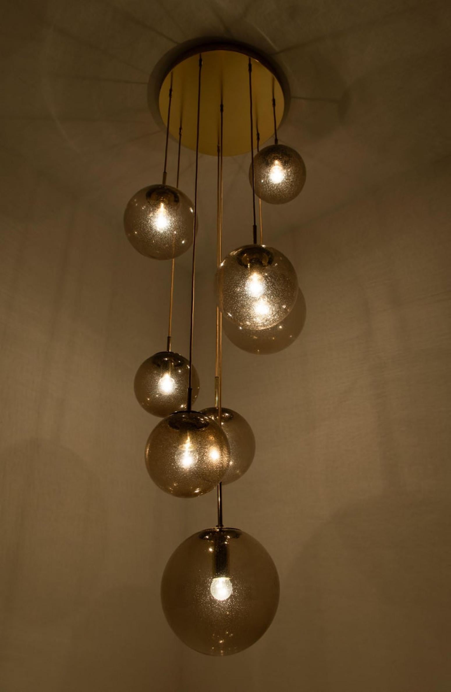 Absolutely amazing huge ceiling mount pendant light fixture with eight different sizes of globes or spheres by Limburg Glashütte, manufacturered around 70s. With hand blown smoked glass globes in 11.8