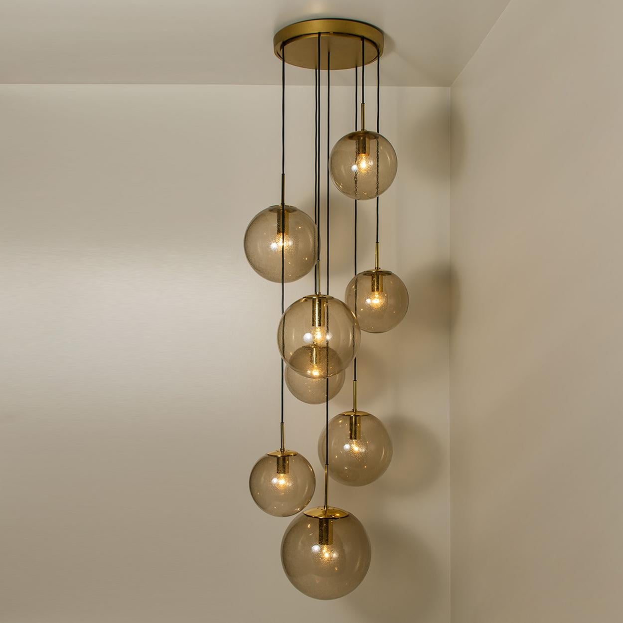Absolutely amazing huge ceiling mount pendant light fixture with eight different sizes of globes or spheres by Limburg Glashütte. With hand blown smoked glass globes in 11.8