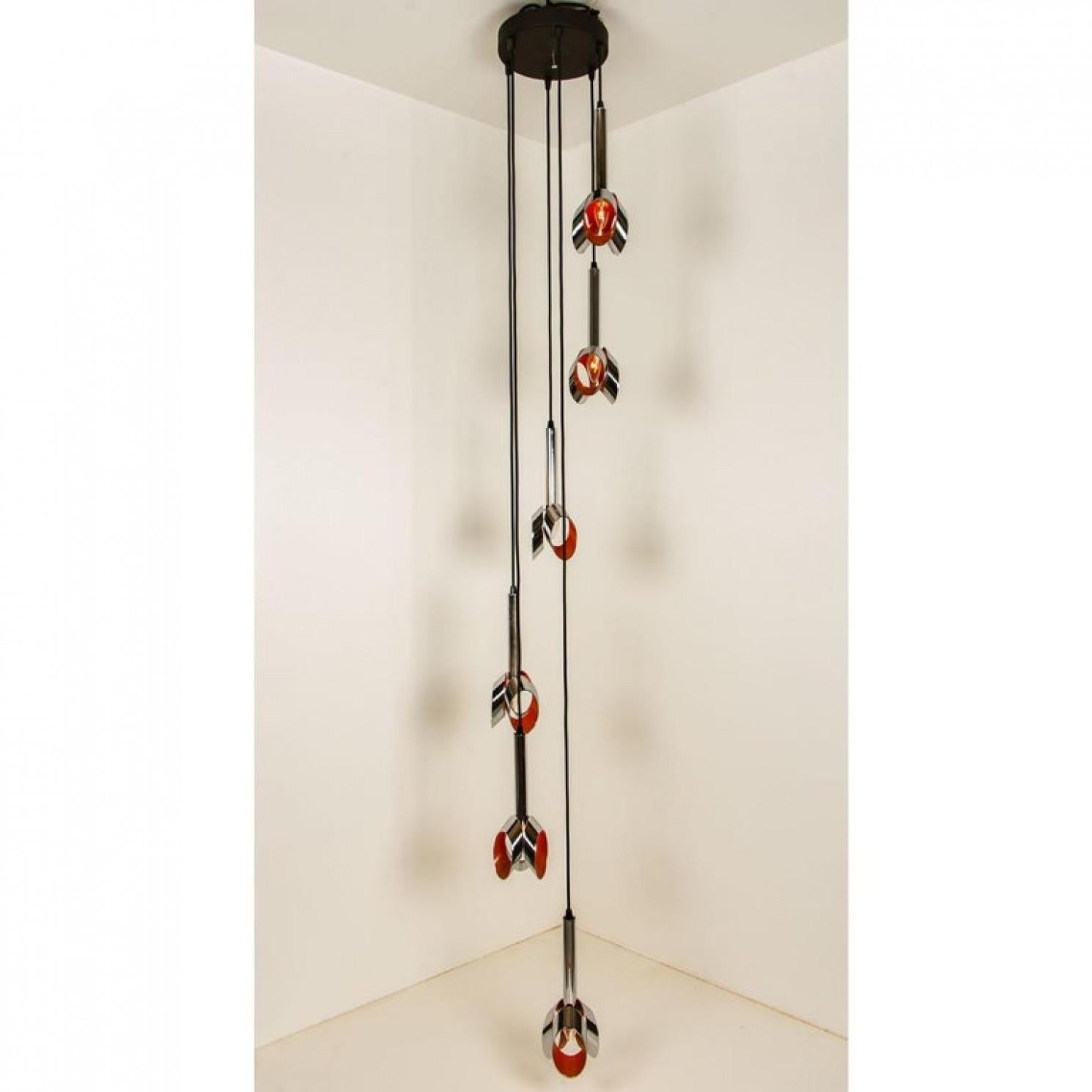 A special cascade with 6 chrome and orange pendants. The light is made in the style of RAAK, a dutch manufacturer of the 60/70's.
The light consists of 6 chrome pendants with a laquered orange inside.

This lamp is can be used for a room, a stunning