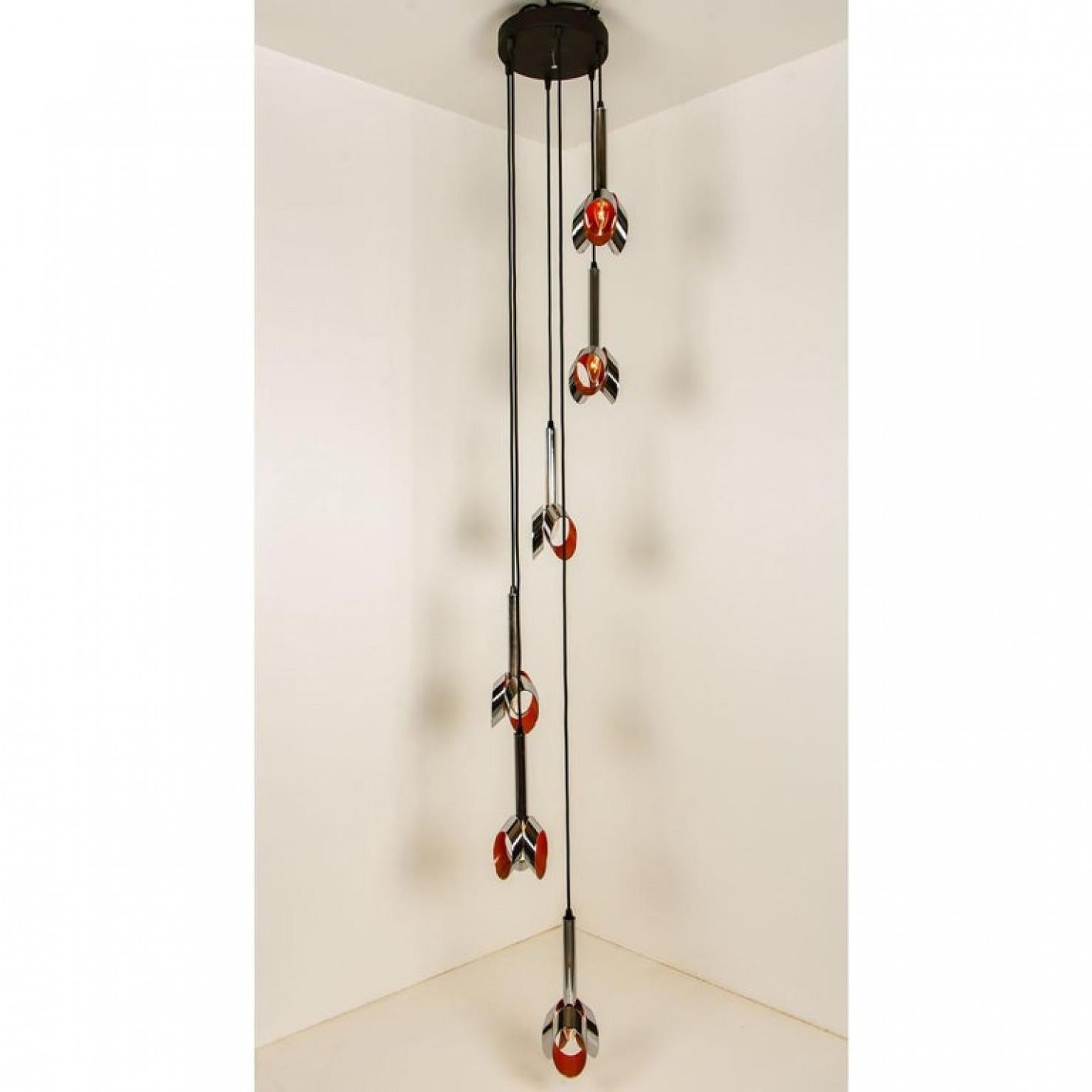 Una cascata speciale con 6 pendenti cromati e arancioni. La lampada è realizzata nello stile di RAAK, un produttore olandese degli anni '60/70.
L'illuminazione è composta da 6 pendenti cromati con un interno laccato arancione.

Questa lampada può