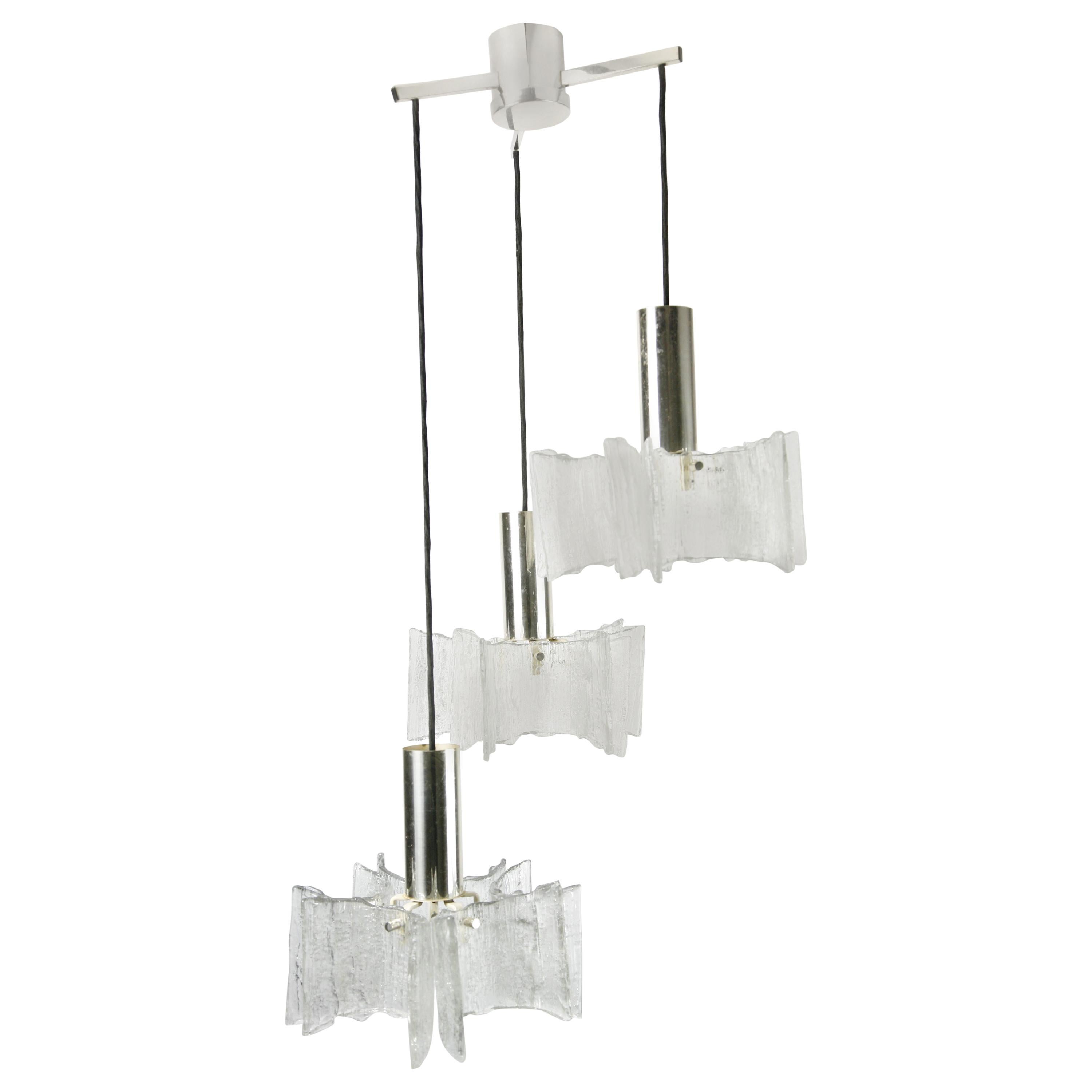 Five individual curved glass elements hold in place with a chrome finial, the glass has texture and is frosted, this cascade is 3 individual lights hanging from a chrome ceiling fitting. 

Each light element is 10