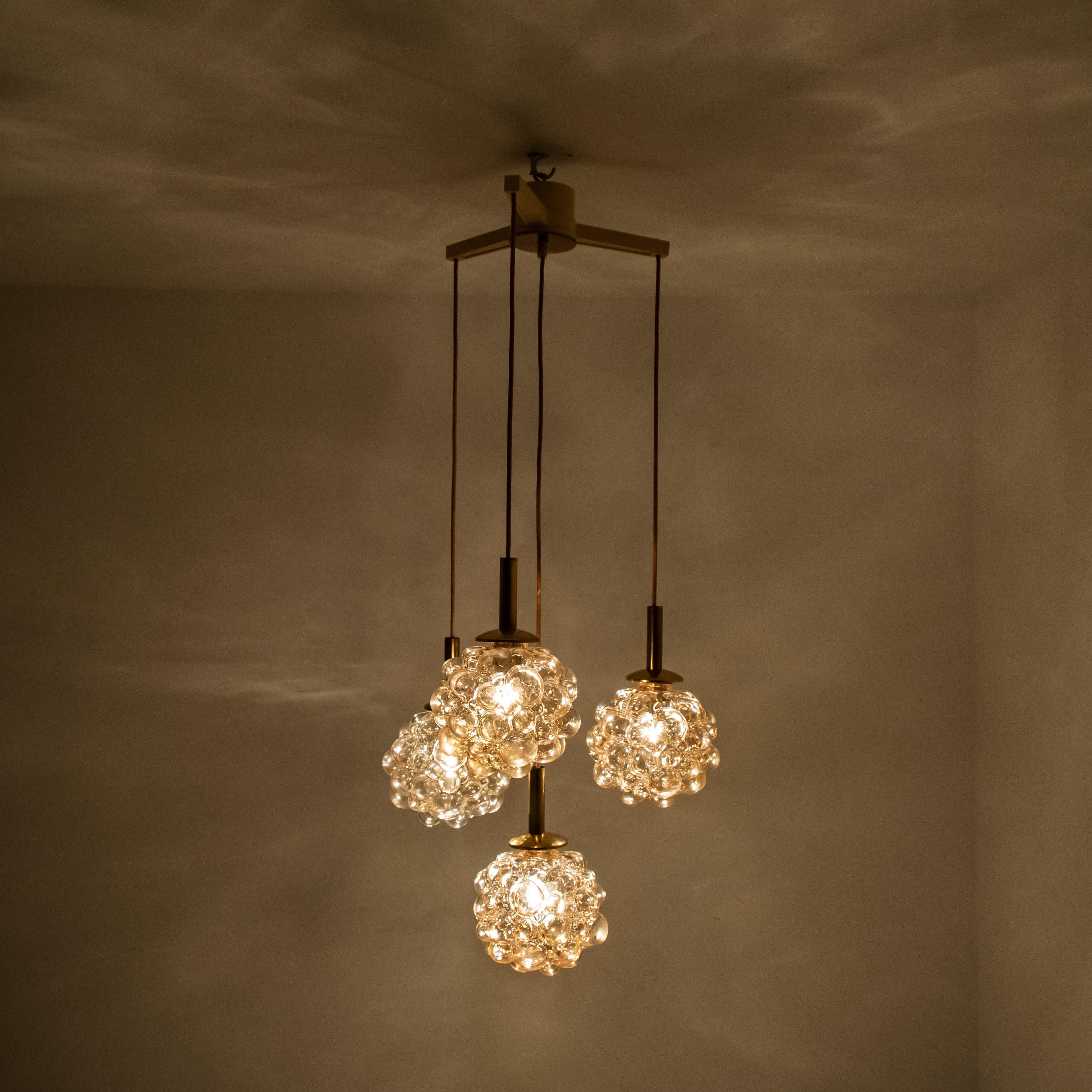 A absolutely amazing and ceiling mount pendant light fixture with four small pedant lights from the designer Helena Tynell. Manufactured in circa 1970 (late 1960s and early 1970s), Germany. 

A design classic, the amber colored or toned of the