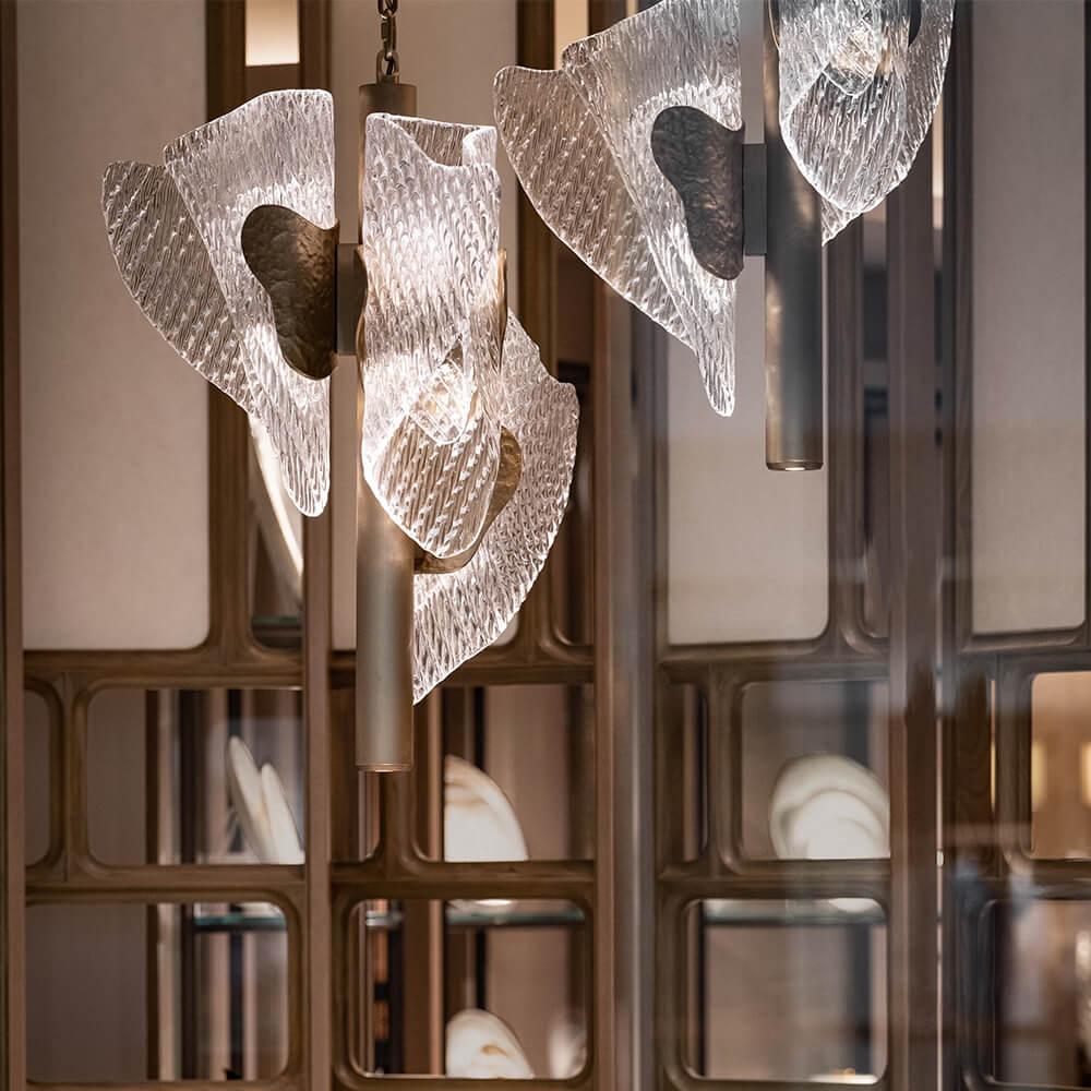 une suspension artistique qui capture la silhouette des rizières en cascade. le verre caste raffiné, fabriqué à la main, s'articule avec des motifs ondulants, tout en étant éclairé par des lumières LED complexes pour fournir une lueur scintillante.