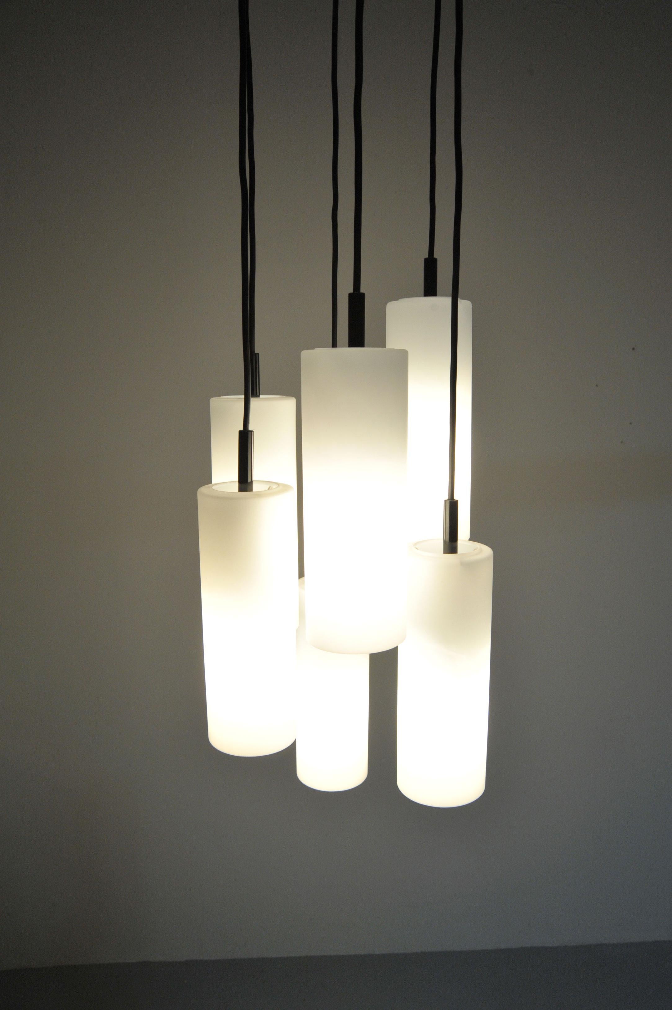 Lampada a sospensione a cascata della metà del secolo scorso di Staff, Germania, degli anni '70. Il design è caratterizzato da sei tubi di vetro testurizzato disposti in una suggestiva cascata, creando un raffinato gioco di luci e forme. Un classico