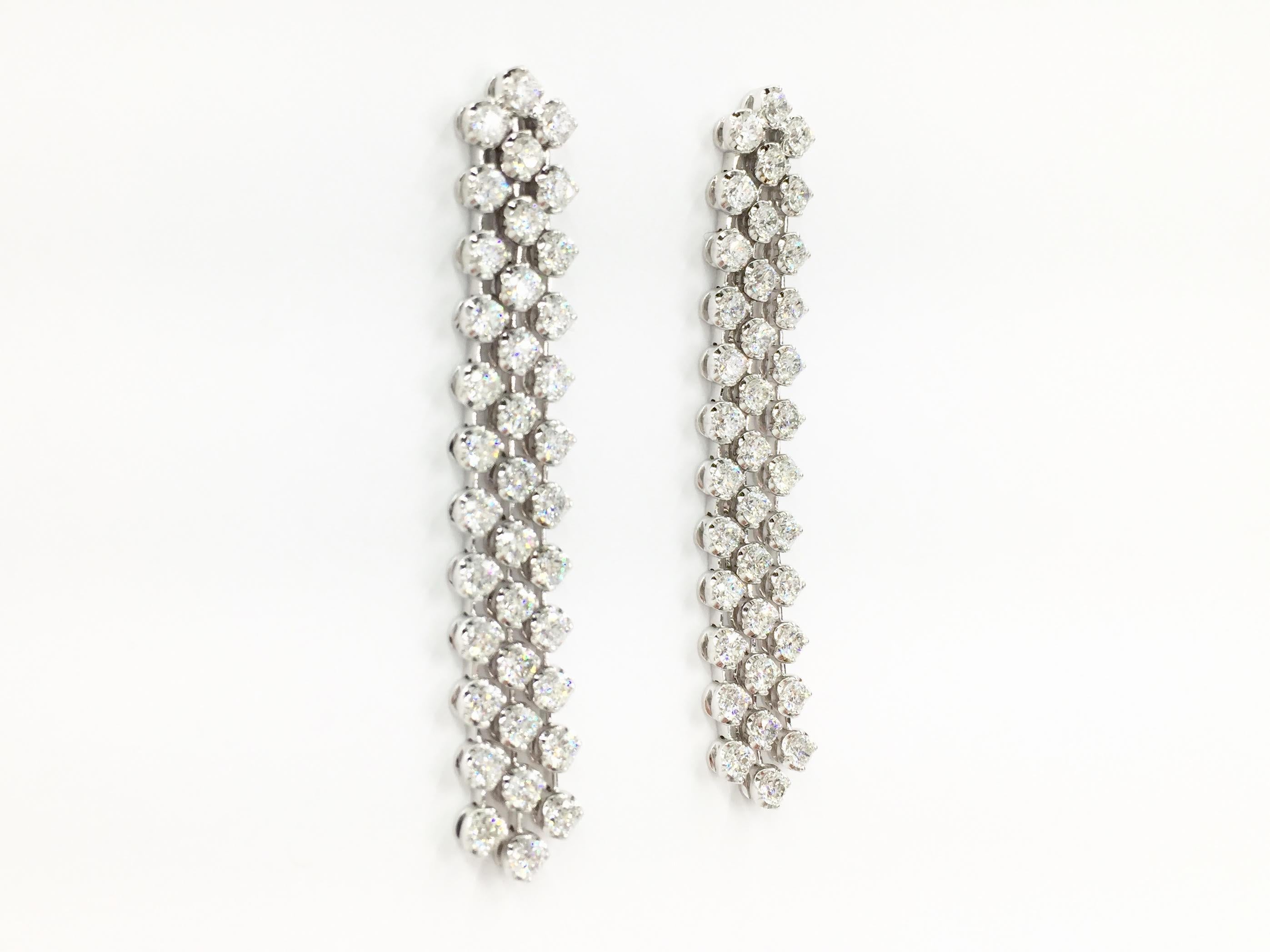 4.34 carats of round brilliant diamonds are stationed beautifully on these modern cascading three strand 18 karat white gold earrings. Earrings have excellent movement, allowing a constant sparkle. Diamond quality is approximately G color, VS2