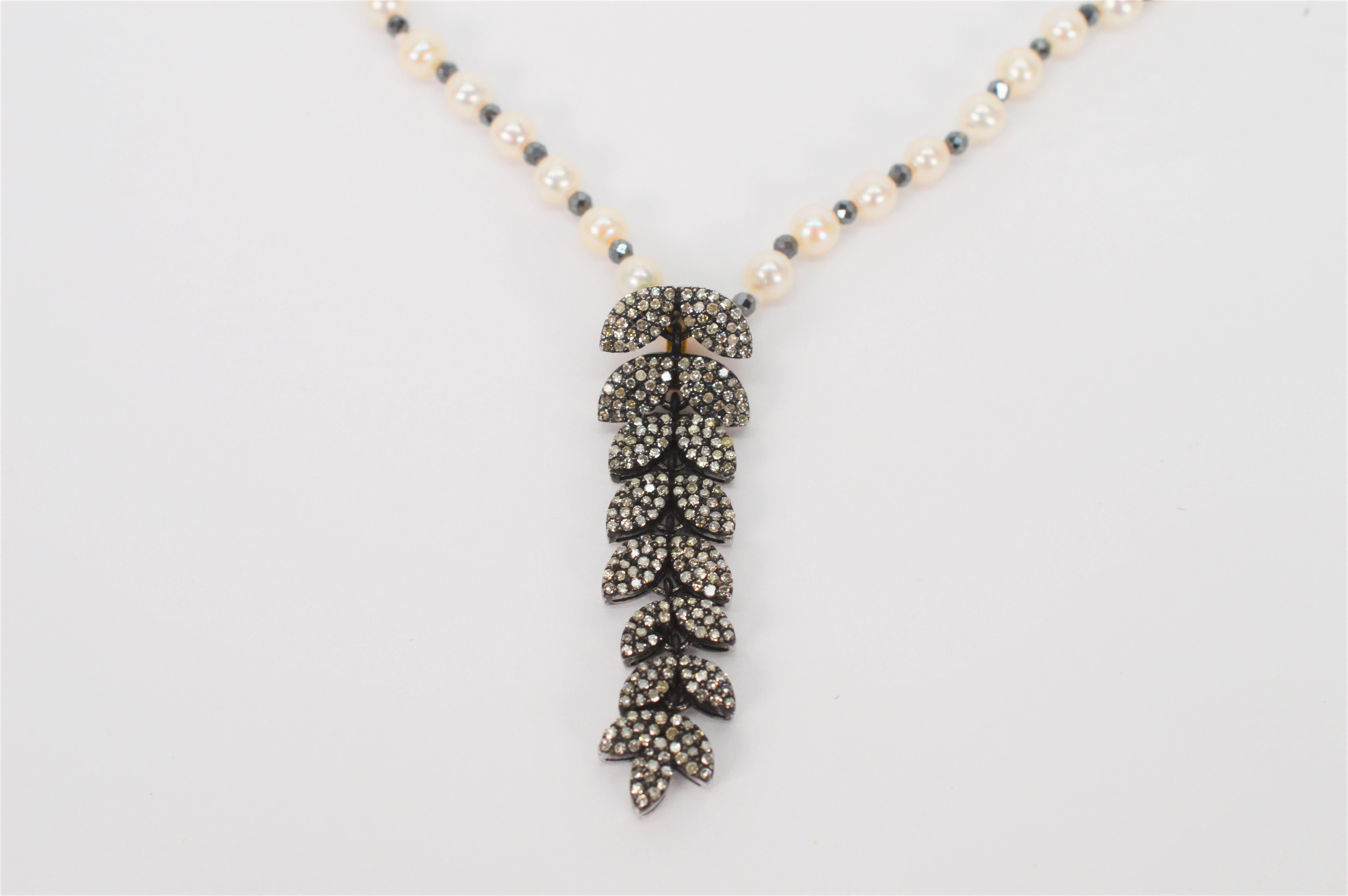 Stunning on that little black dress or sweater is this unique diamond and sterling silver cascading pendant adorning a hand strung 27 inch AAA Lustrous Round Akoya pearl necklace. The 4 mm pearl strand is accented with natural pyrite crystals and