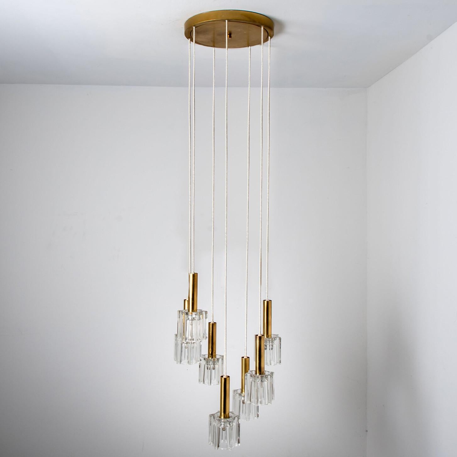 A beautiful and unique clear glass pendant, made in the 1970s by German designer and company Peill Putzler.
The lampshade is made of a clear glass with an brass base, in the shape of a cascade-like spiral. Each light requires 7 E14