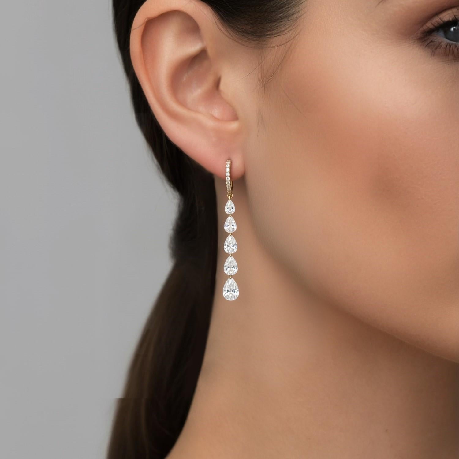 Élevez votre élégance avec ces boucles d'oreilles poire en cascade, fabriquées de manière experte en luxueux or 14 carats. Présentant une gracieuse séquence de pierres taillées en poire qui s'écoulent délicatement de boucles d'oreilles serties de