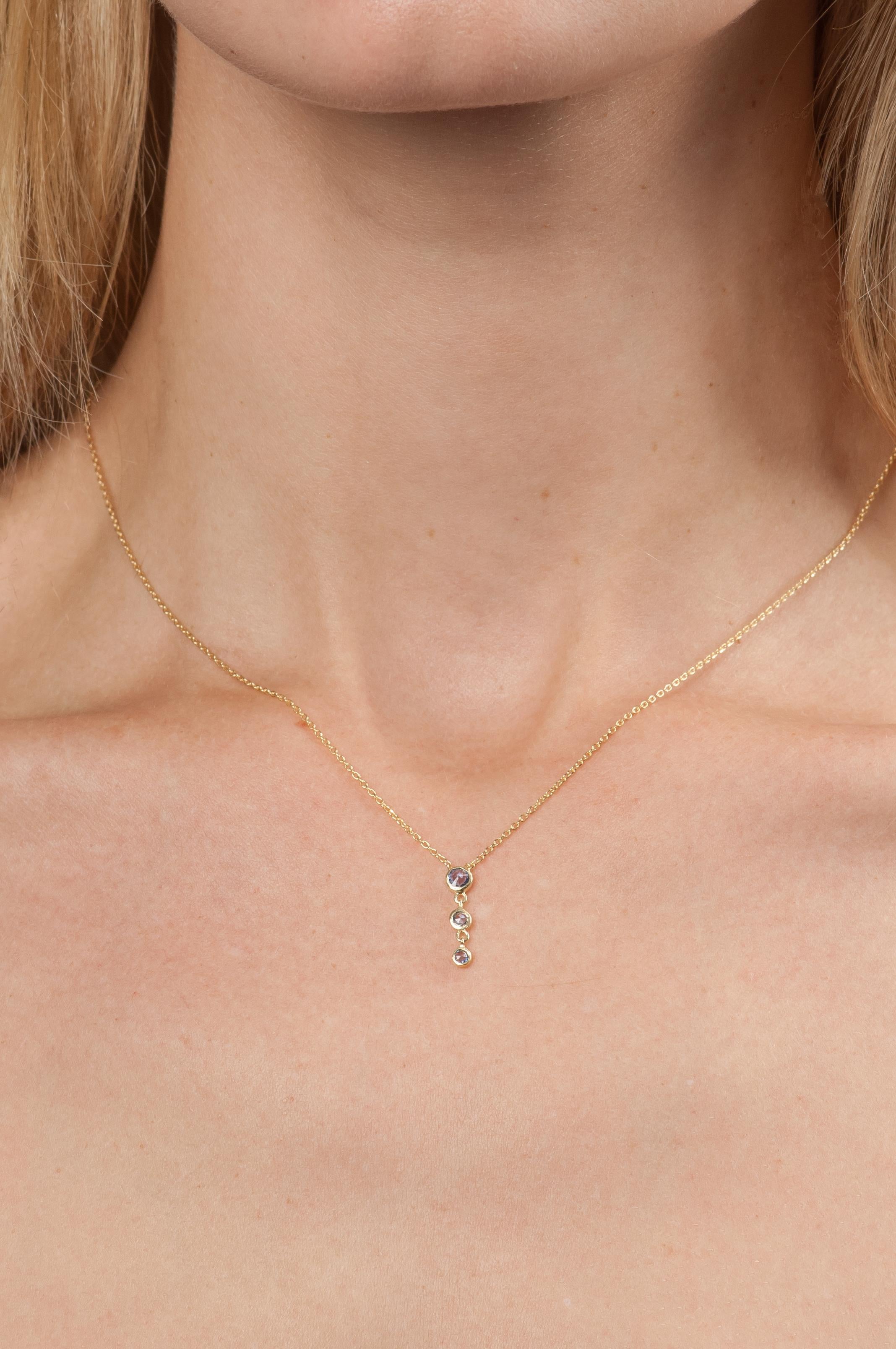A row of graduated rose cut pink sapphires adds just the right amount of sparkle to this delicate necklace.

18K yellow gold chain with a drop pendant of 3 graduated rose cut pink sapphires (0.25 tcw)
16 inch chain