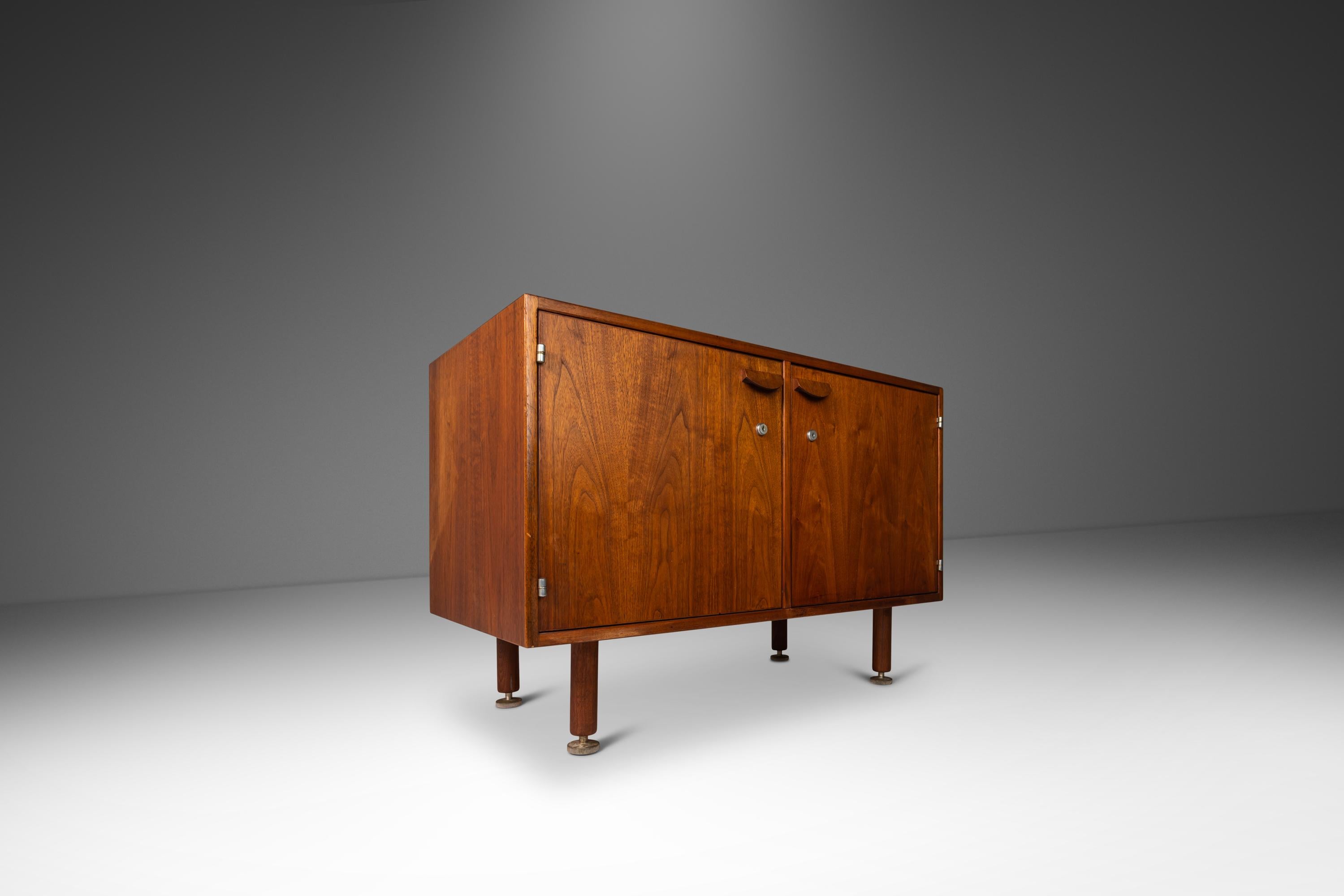 Introducing a rare two-door cabinet designed by Jens Risom produced in the Unite States in the early 1960's. Constructed from a mix of solid and veneered American Black Walnut this cabinet, which was recently featured prominently in the third season