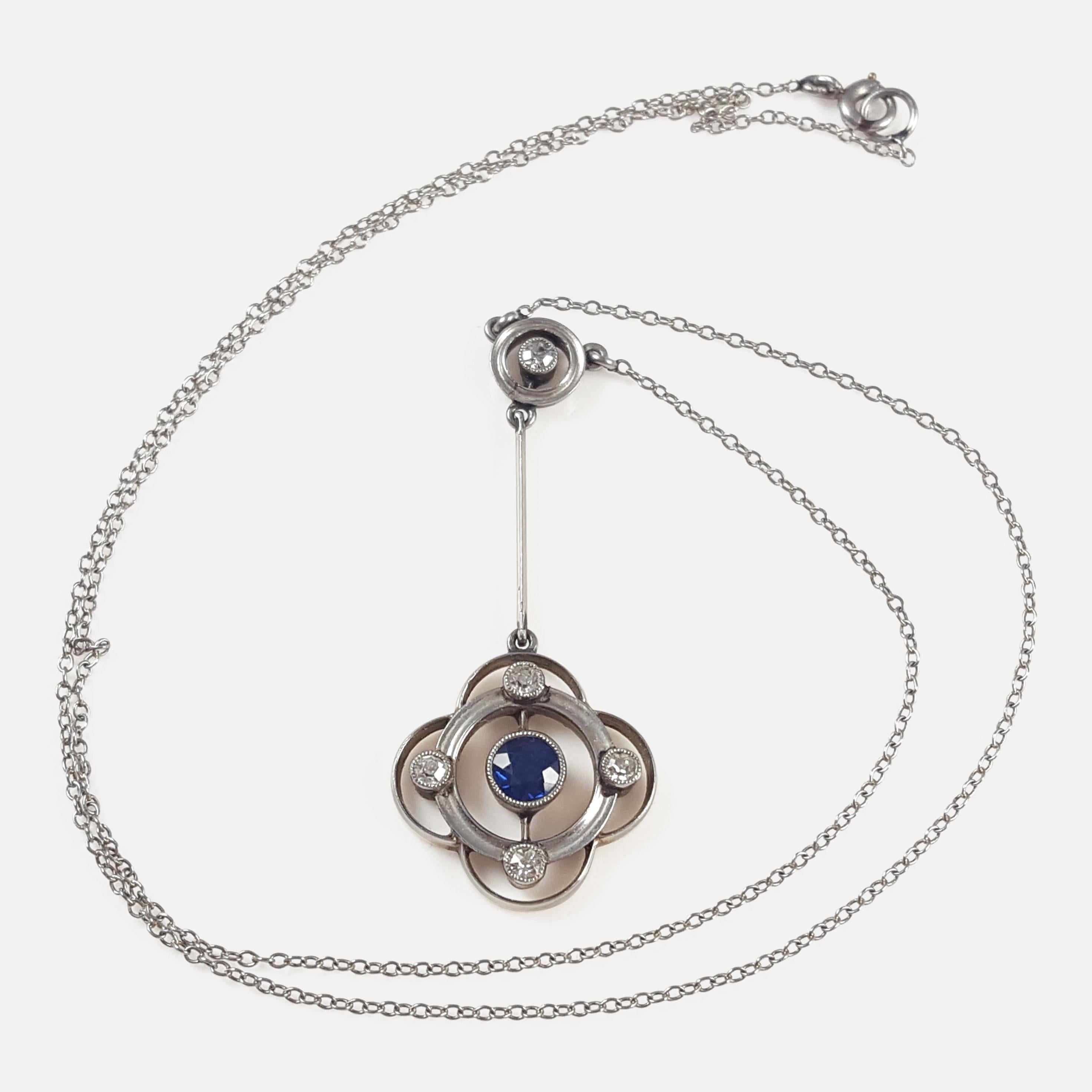 Description: - This is a fine Art Deco period 15 karat gold sapphire, & diamond drop pendant necklace.  The necklace suspends a quatrefoil design drop, millegrain-set with a circular-cut blue sapphire, and embellished with single-cut diamonds, to a