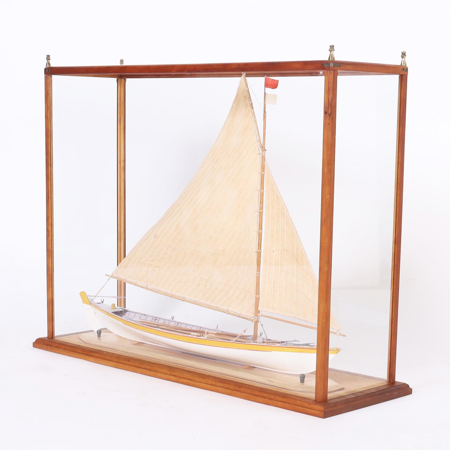 Impressive handmade whaling longboat model with canvas sails and a realistic painted wood hull complete with oars and harpoons. Presented in a custom mahogany and glass case with brass finials.