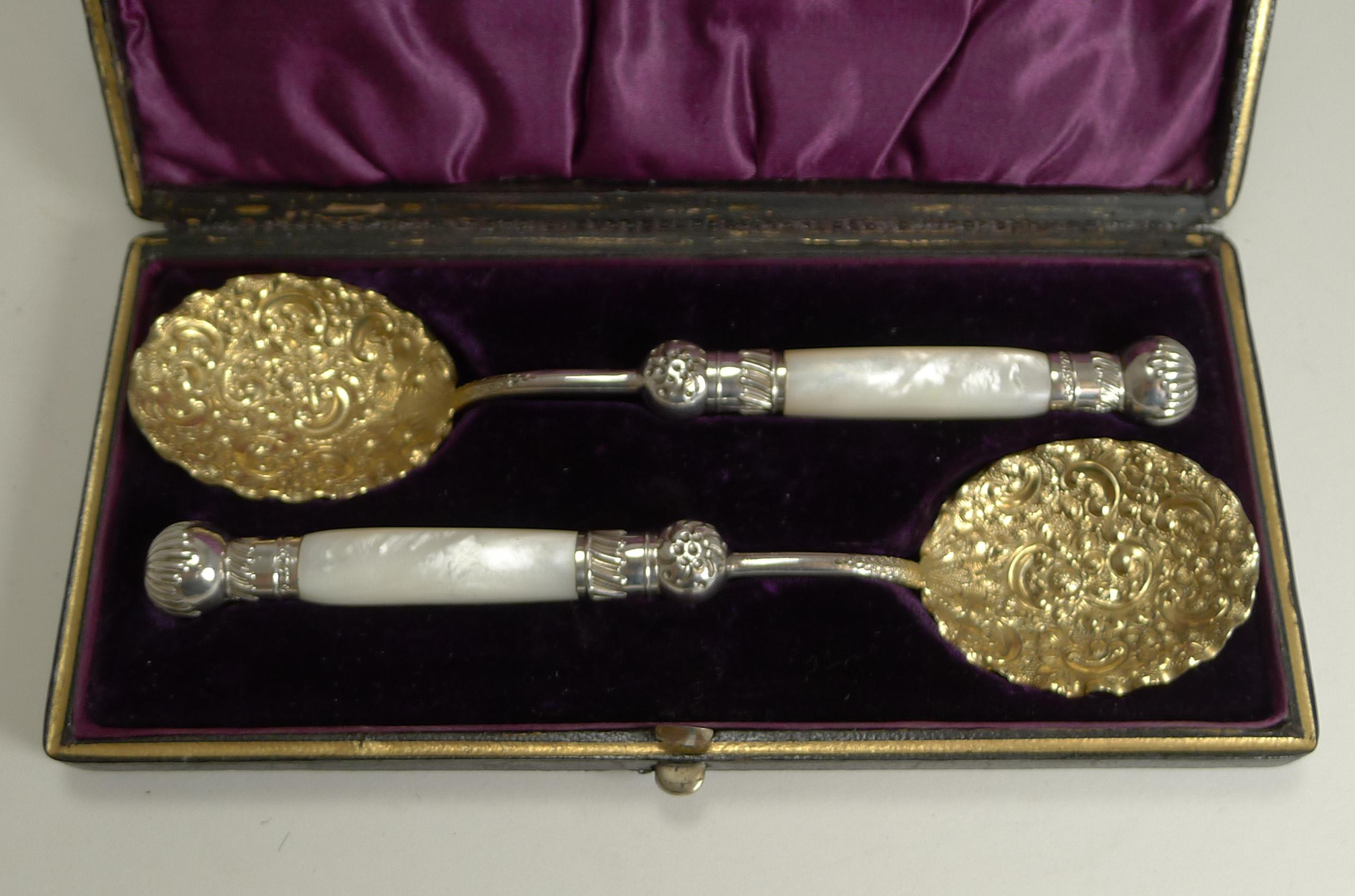 A stunning pair of Victorian serving or preserve spoons sitting in their original presentation case.

Each spoon has a carved cylindrical mother of pearl handle with silver plated fittings. Each terminal has an English registration number (50720)