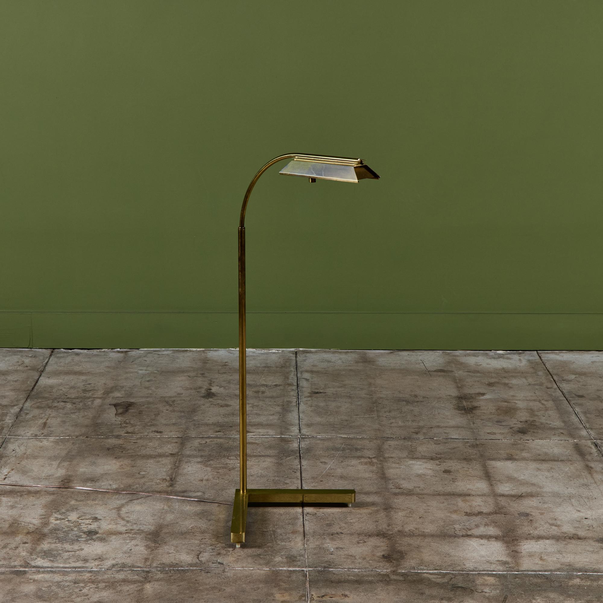 Brass floor lamp for Casella, c.1970s, USA. The brass floor lamp features an oblong brass shade attached to a curved stem that offers dimmable focused task lighting and an adjustable height. The arched pole terminates in a heavy brass v-bar base.