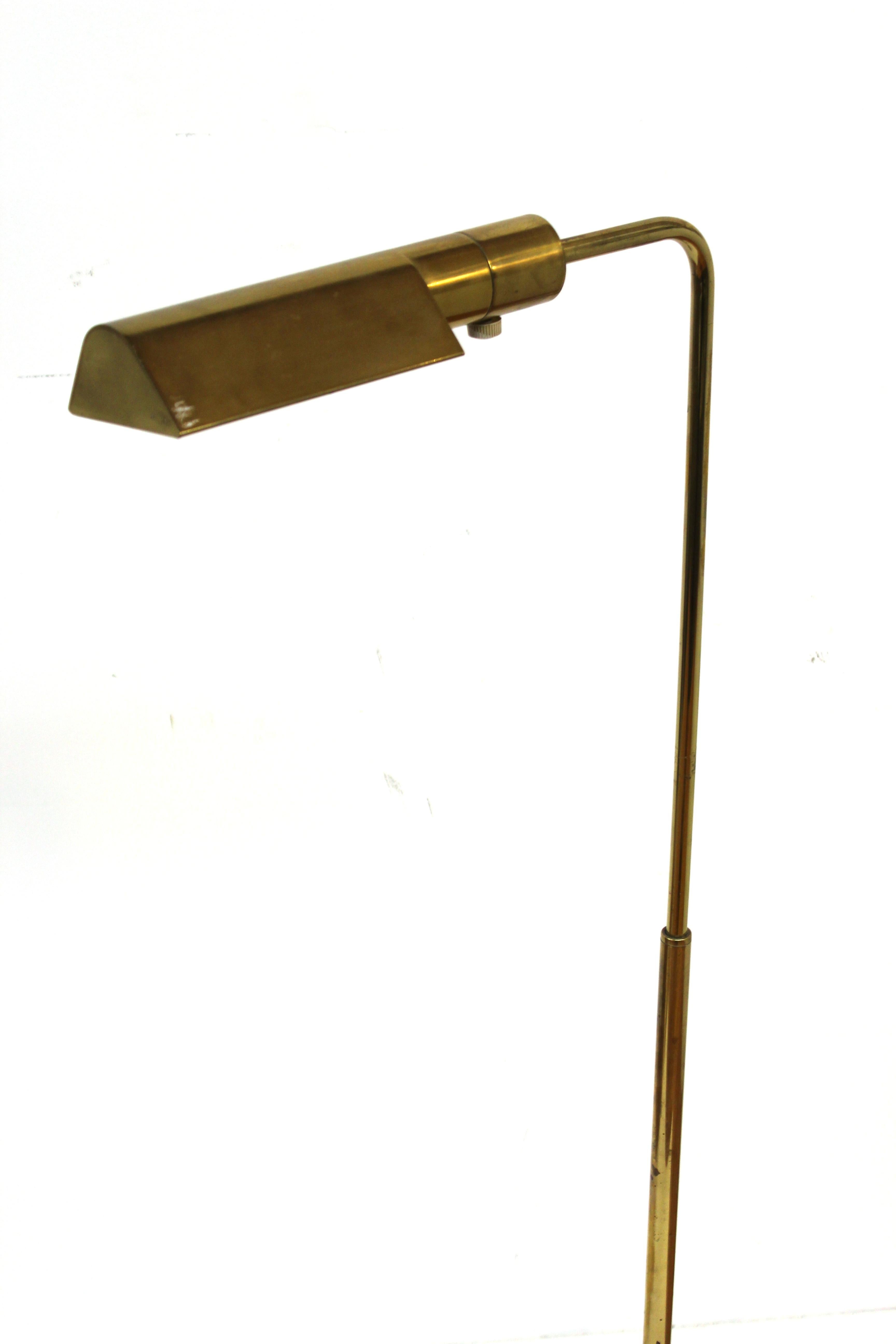 Mid-Century Modern heavy brass pharmacy floor lamp made by Casella. The piece has an adjustable neck and a moving shade. Makers label on the bottom. In great vintage condition with age-appropriate wear and use.