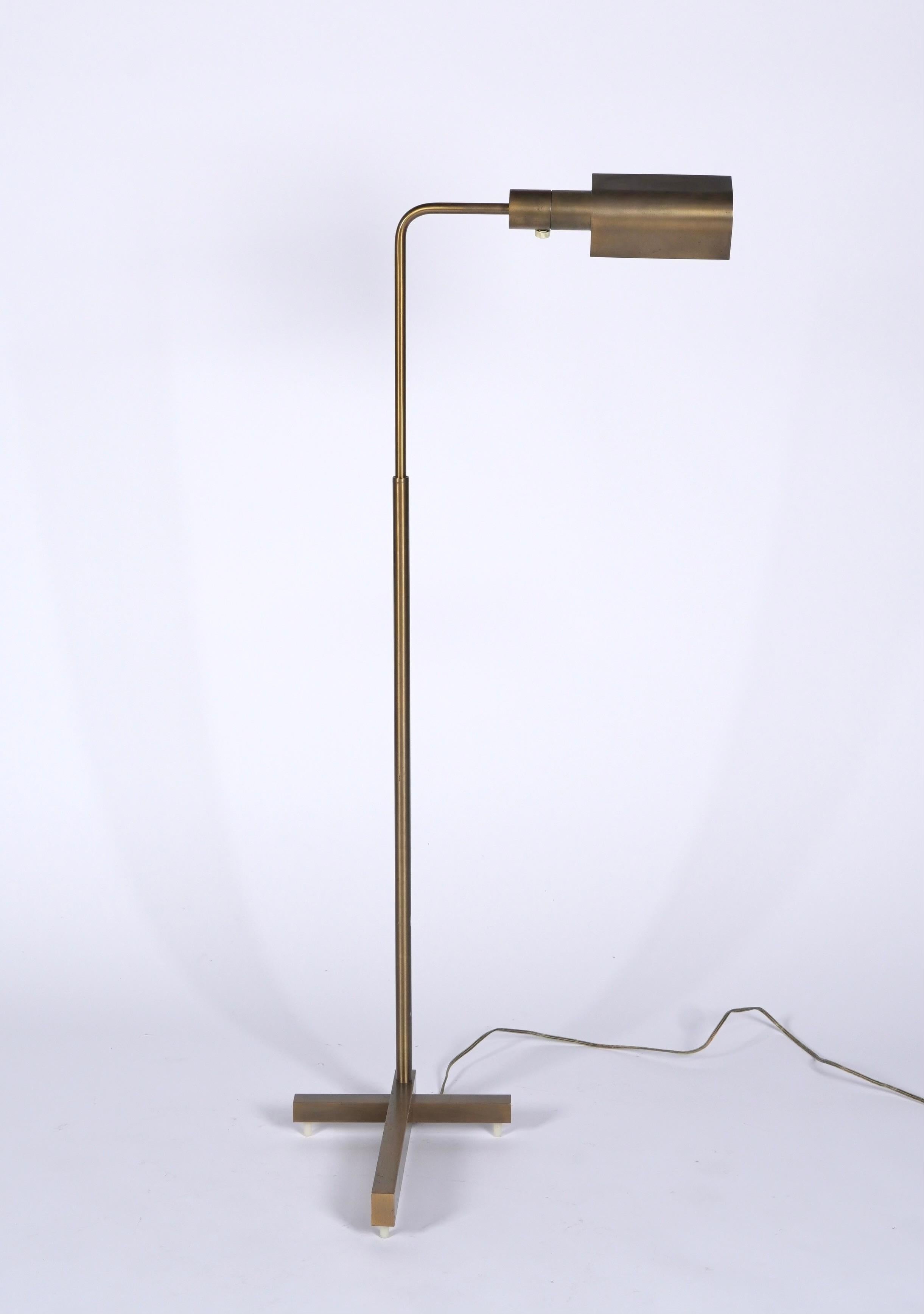 Mid-Century Modern height adjustable swivel pharmacy floor lamp by Casella Lighting of San Francisco. The lamp features a rich patinated brass finish and a rare T-shaped base. The lamp adjusts from approx. 34 inches high to 48 inches high with a