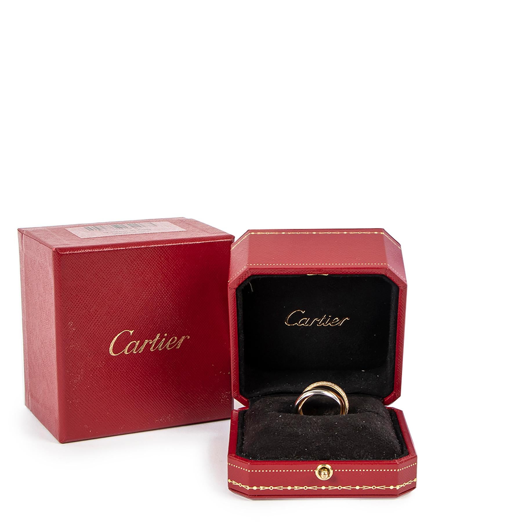 Cette bague Trinity iconique de Cartier en petit modèle, or blanc 750/1000, or rose 750/1000, or jaune 750/1000, sertie de diamants taille brillant.

Livré avec :
Boîte
