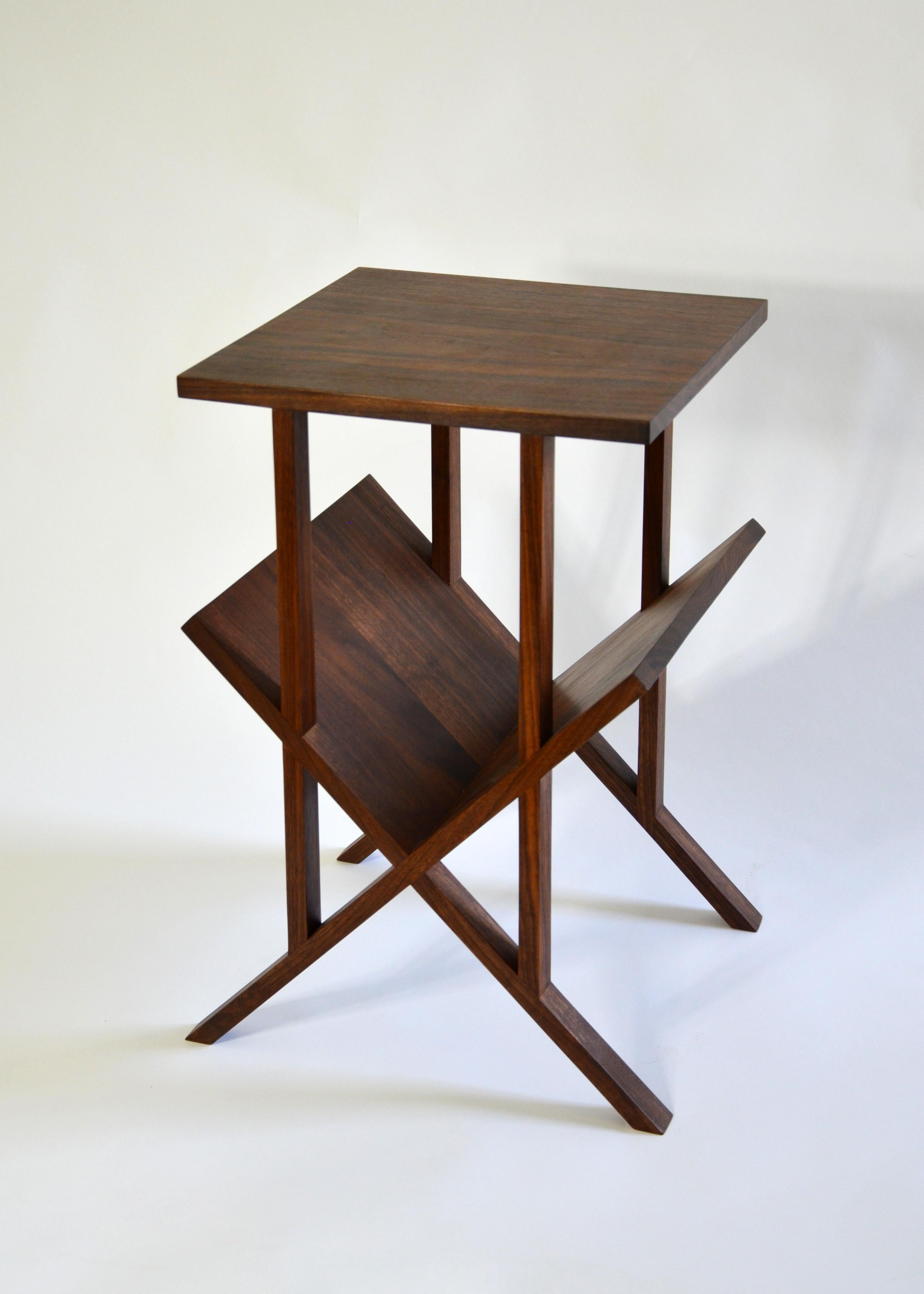Der minimalistische und raffinierte Lap Table ist ein vielseitiges Stück, das leicht als Beistelltisch, Beistelltisch oder Nachttisch mit einem abgewinkelten Regal für Bücher und Zeitschriften verwendet werden kann. Bei direkter Betrachtung zeigen