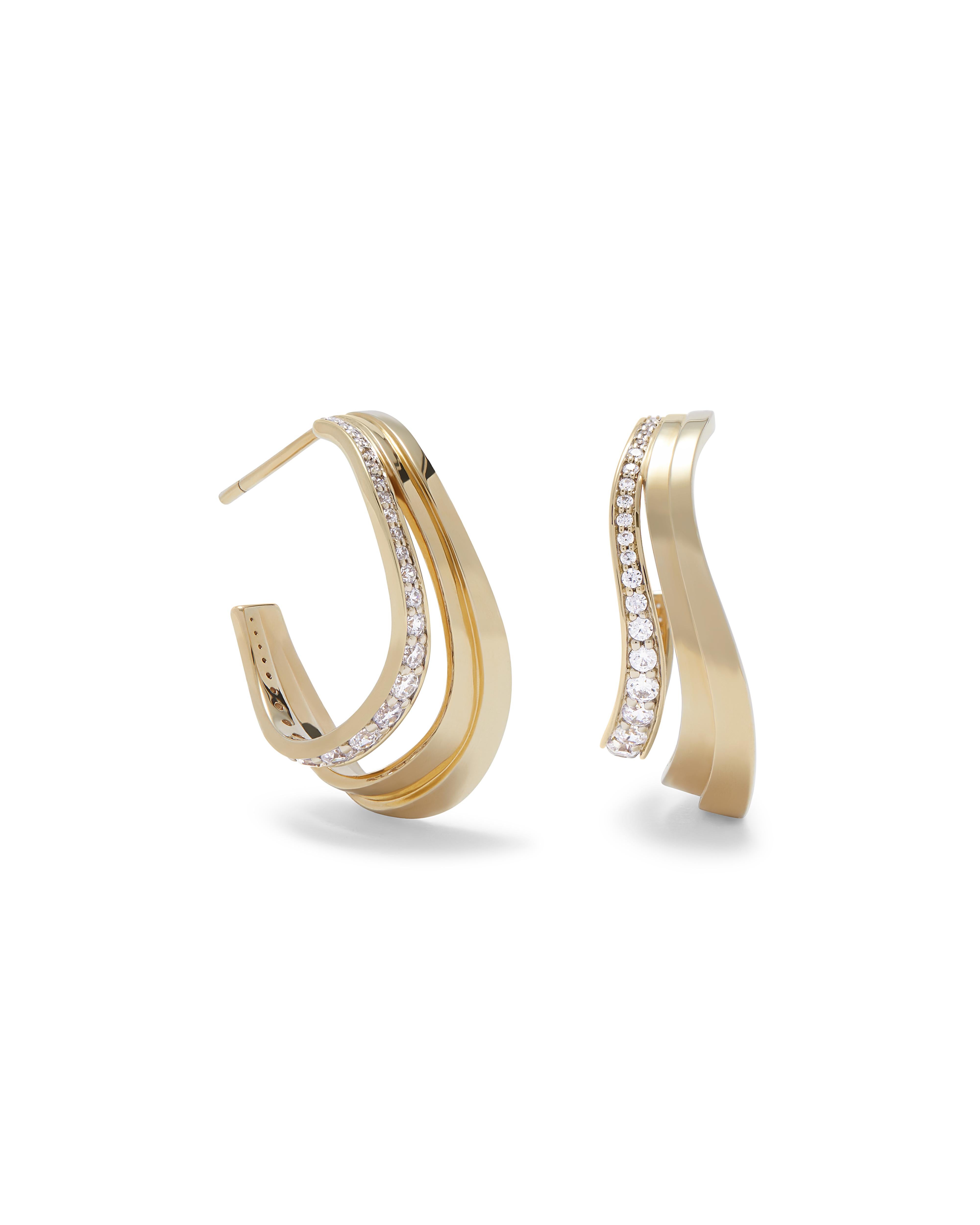 Inspired by the flowing curves of landforms, these sculptural 18k yellow gold hoop earrings are at once modern yet feminine. The hoops feature a tiered design with soft flowing lines that are beautifully accented with brilliant cut diamonds.  Hoops