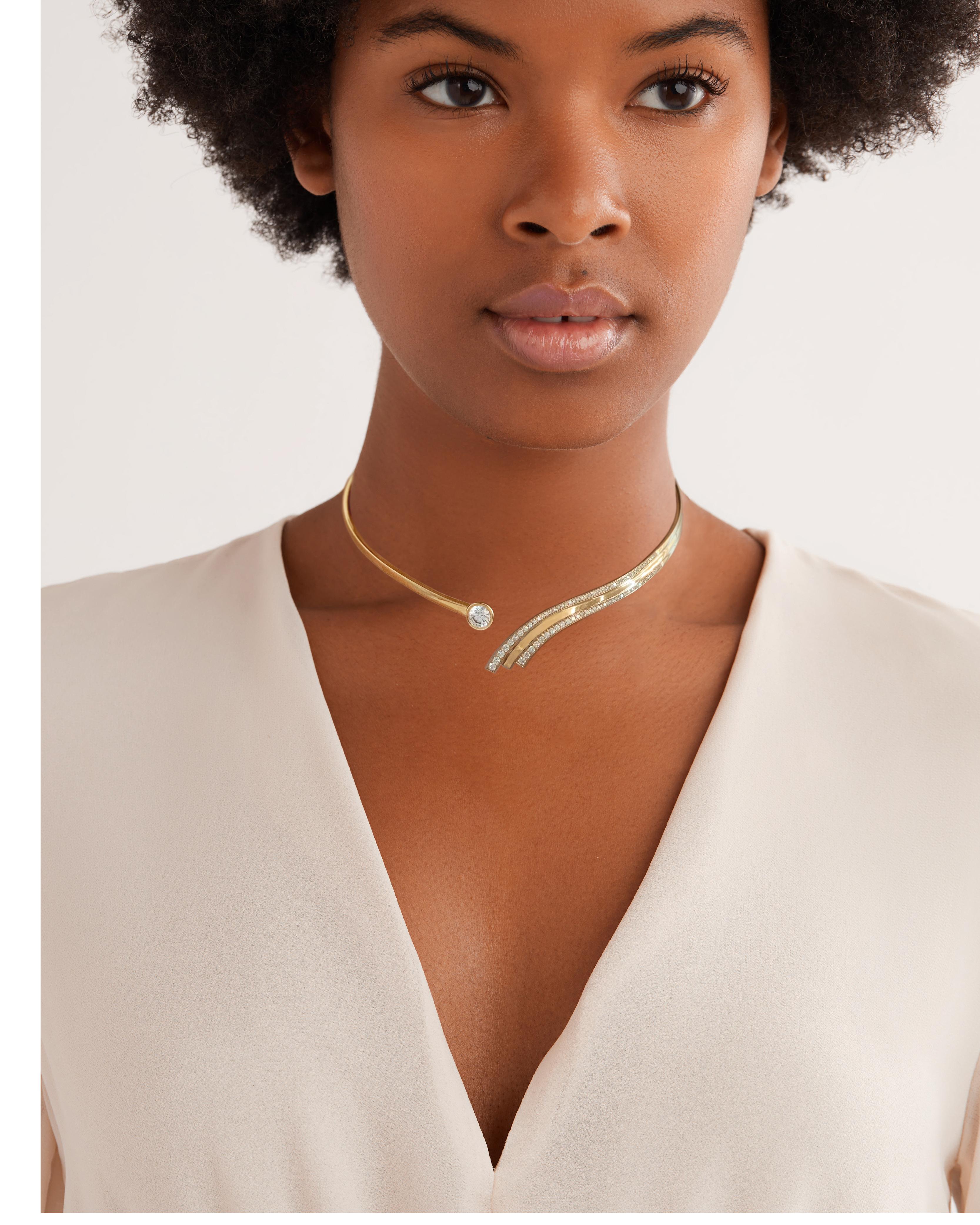 A stunning 18K yellow gold choker with curving, diamond pave wave detail. The choker is set with a 1.25 ct brilliant cut round diamond. The choker features a slim hinge at the back for a beautiful fluid look. 
-Sits at the collarbone
-Inner Diameter