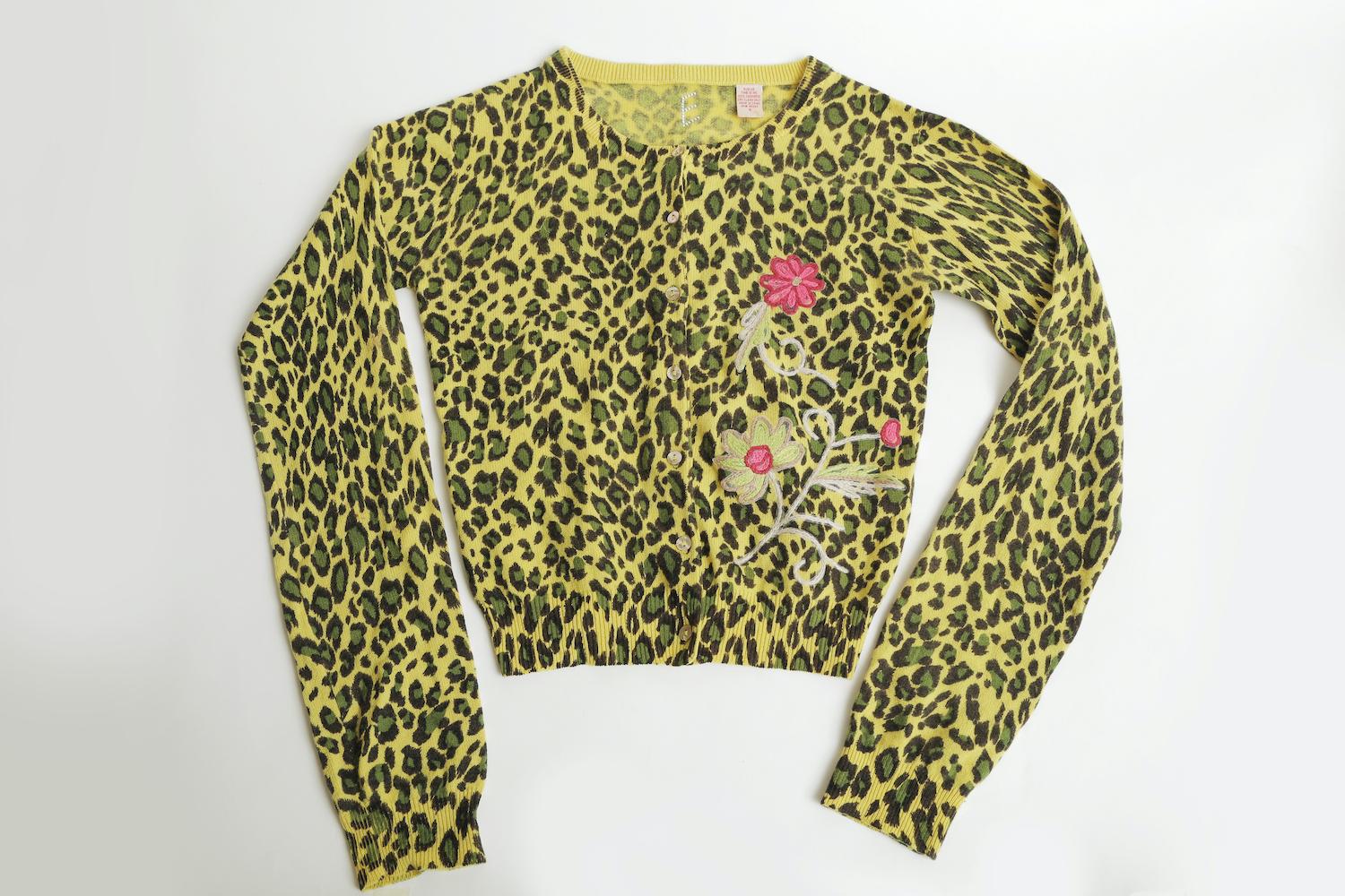 This happy and vibrant button down cashmere sweater is in tones of black, chartreuse yellow and green print of leopard with one side of embroidered flowers. The sleeves are long to be pushed up and the length is short. It is a size small and was