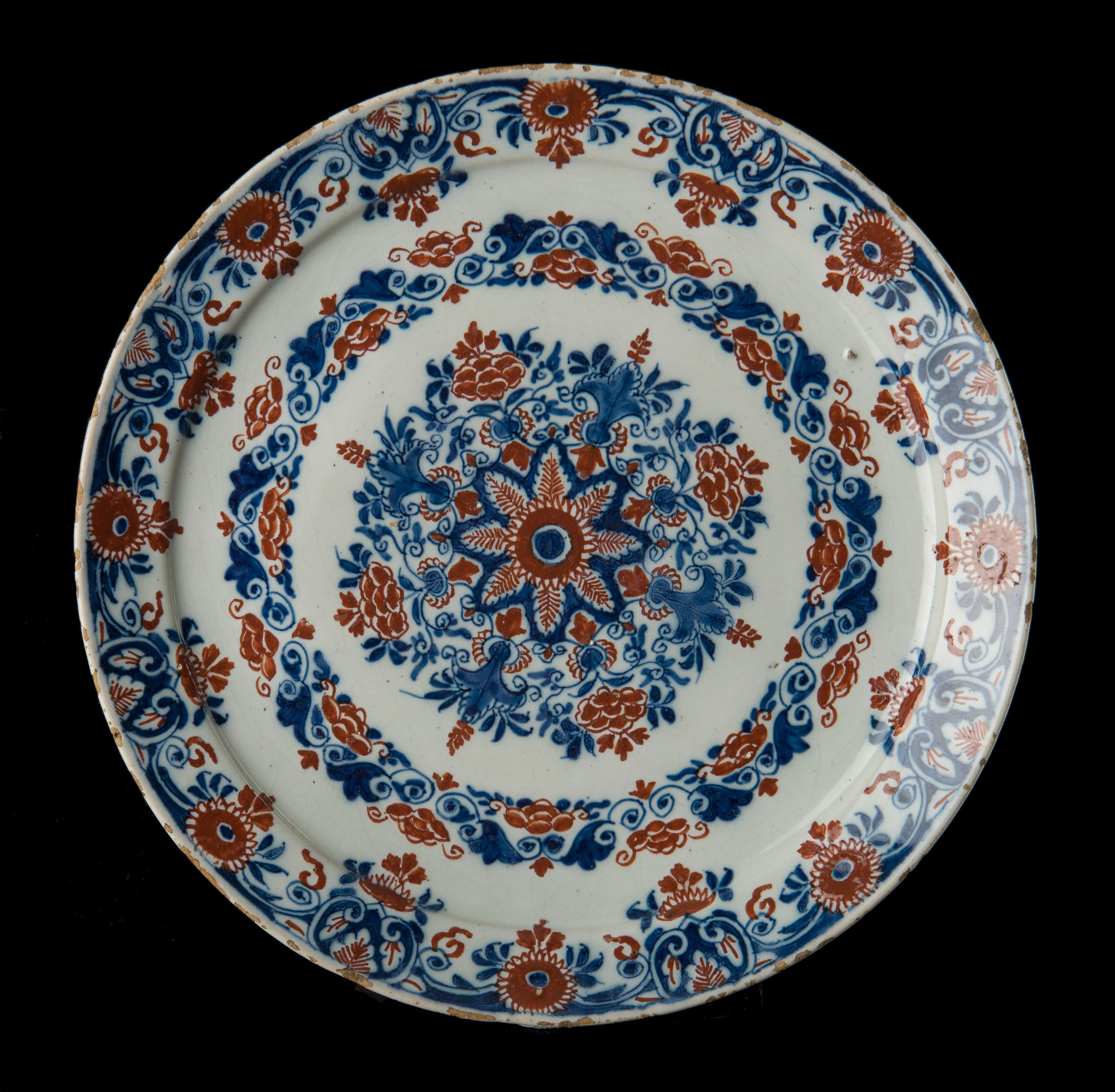 Cashmere plate. Delft, 1701-1722. The Greek A pottery. 
Mark: APK, period of Pieter Kocx (1701-1703) or his widow Johanna van der Heul (1703-1722) 

The Plate is painted with a floral decor in blue and red, the so-called cashmere palette. A