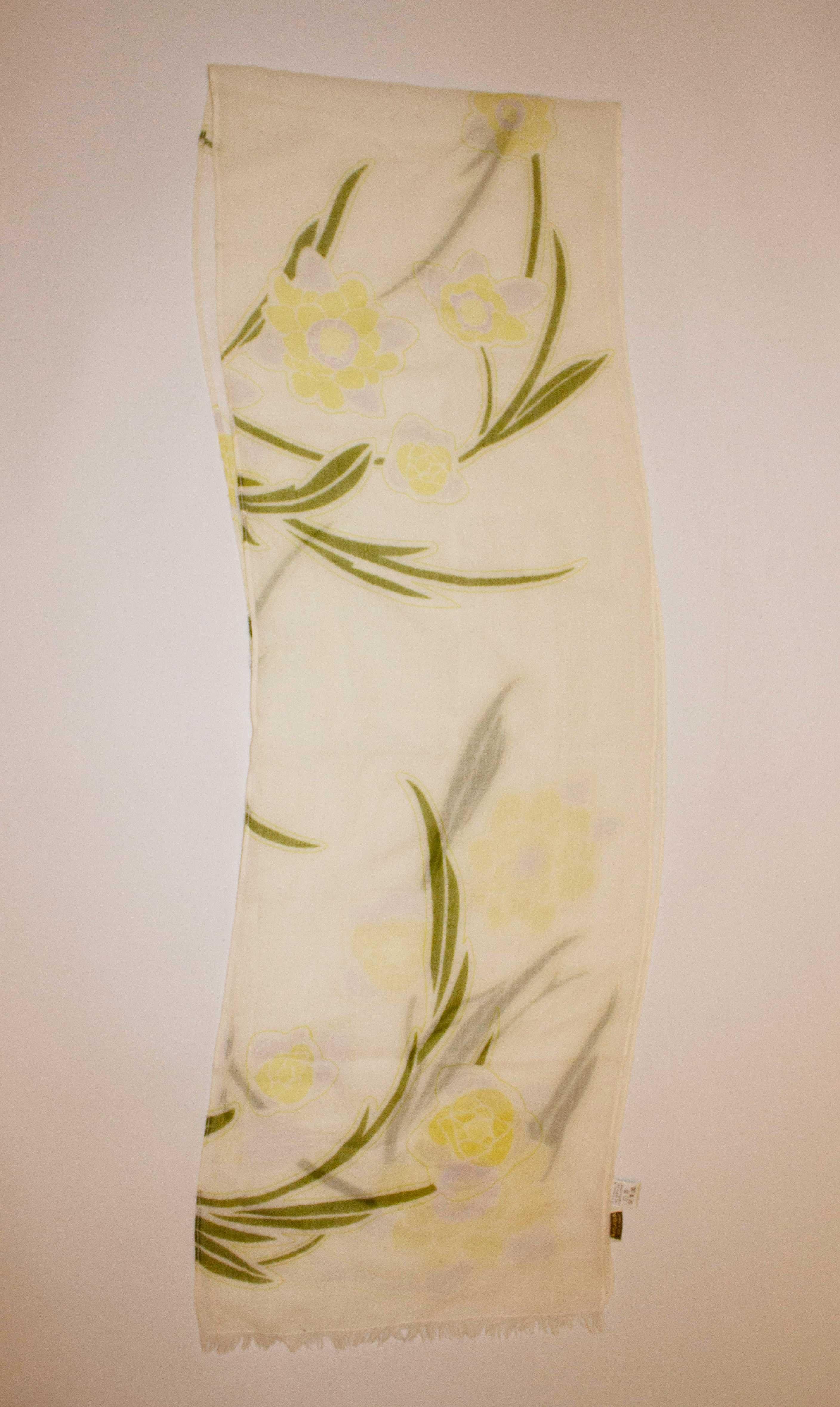A pretty floral cashmere scarf by Agnona. The scarf measures 13'' x 72''  and has a floral design.