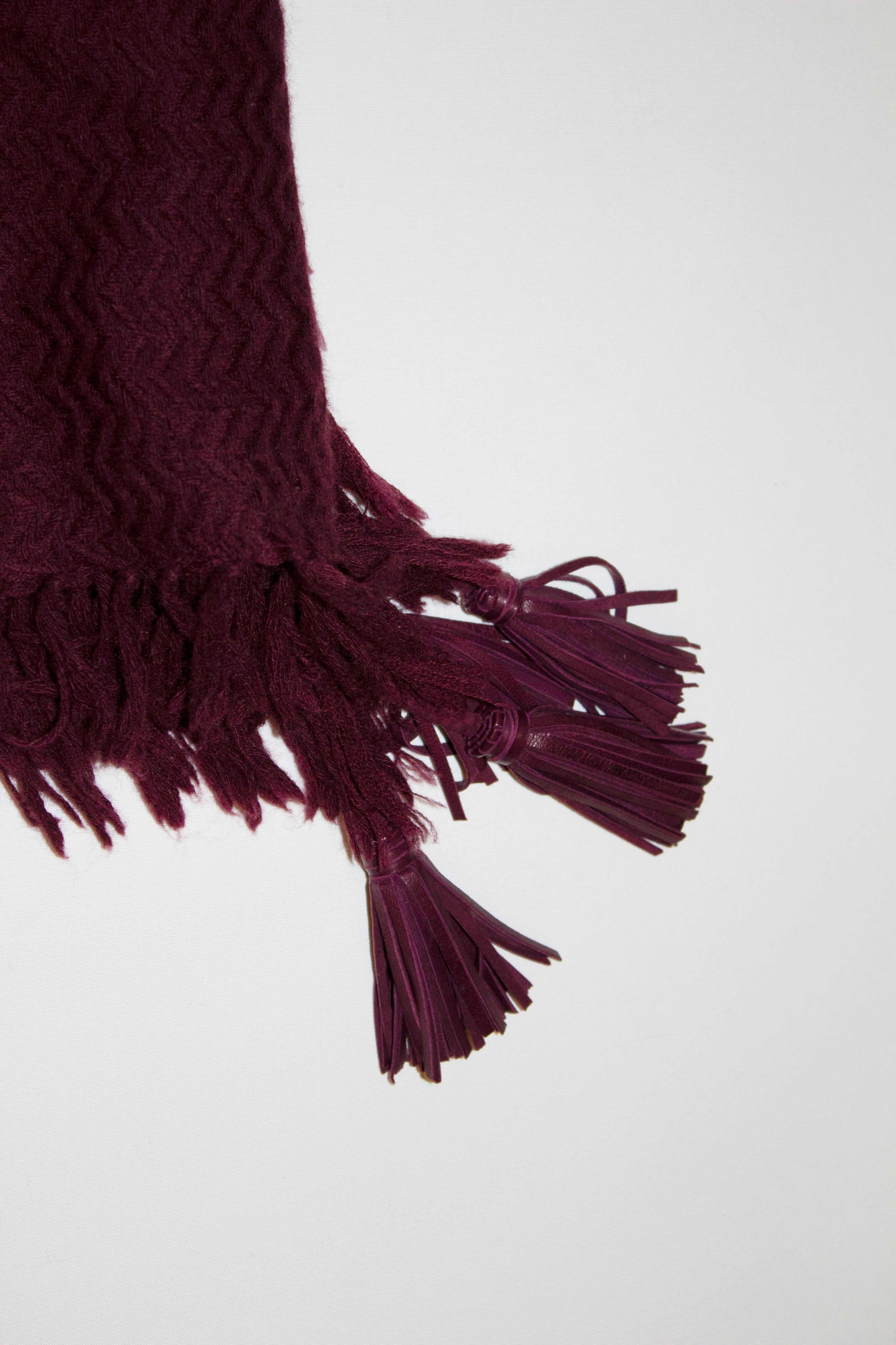 A super soft Cashmere and wool mix scarf by French luxury firm Douce Gloie. In a lovely plum colour, the scarf scarf has a leather trim at each corner. Measurement 47'' x 47''
