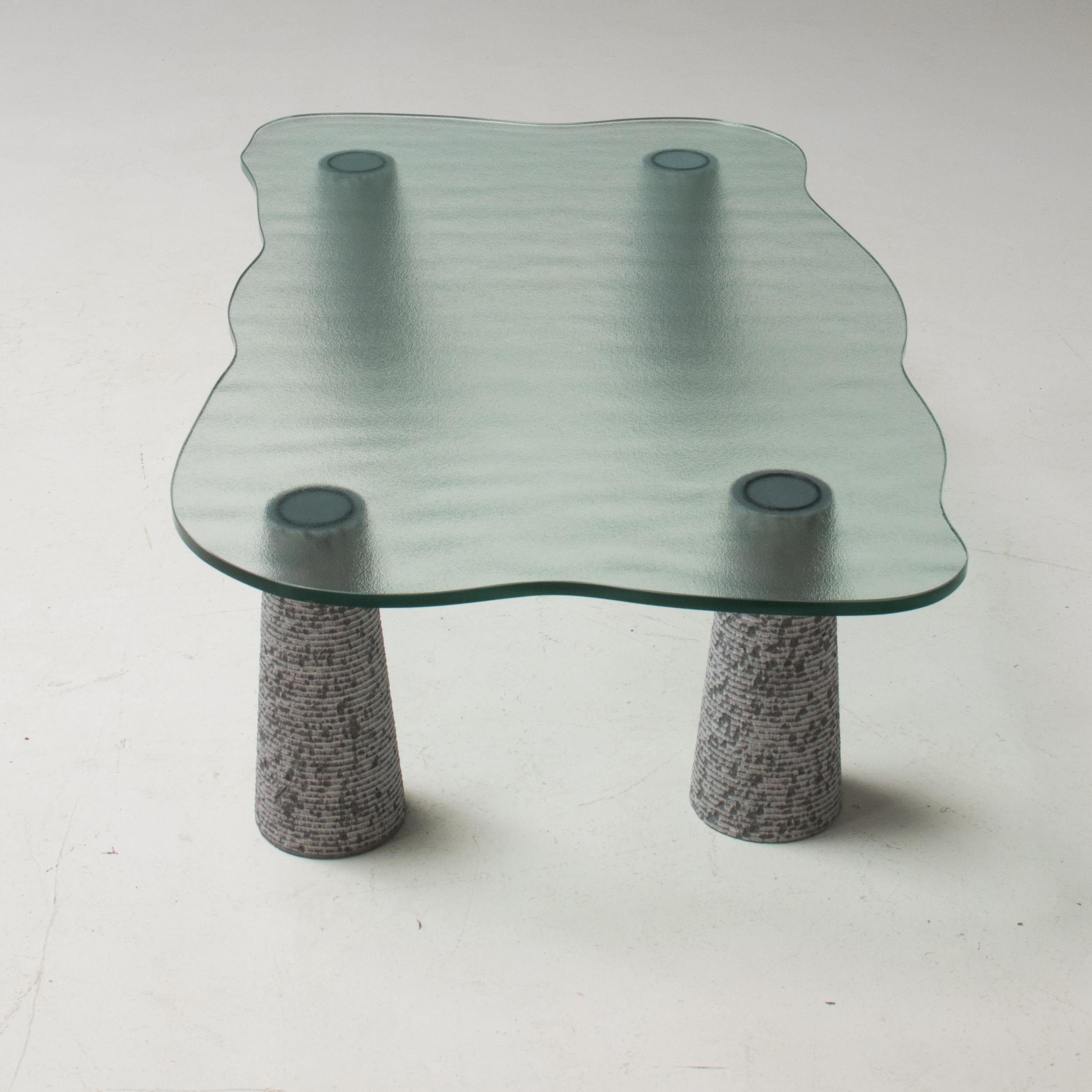 A fantastic example of postmodern Italian design, this Casigliani coffee table was produced in the 1980s.

The coffee table features four individual conical shaped legs sculpted from grey marble, each with a similar textured surface, which allows