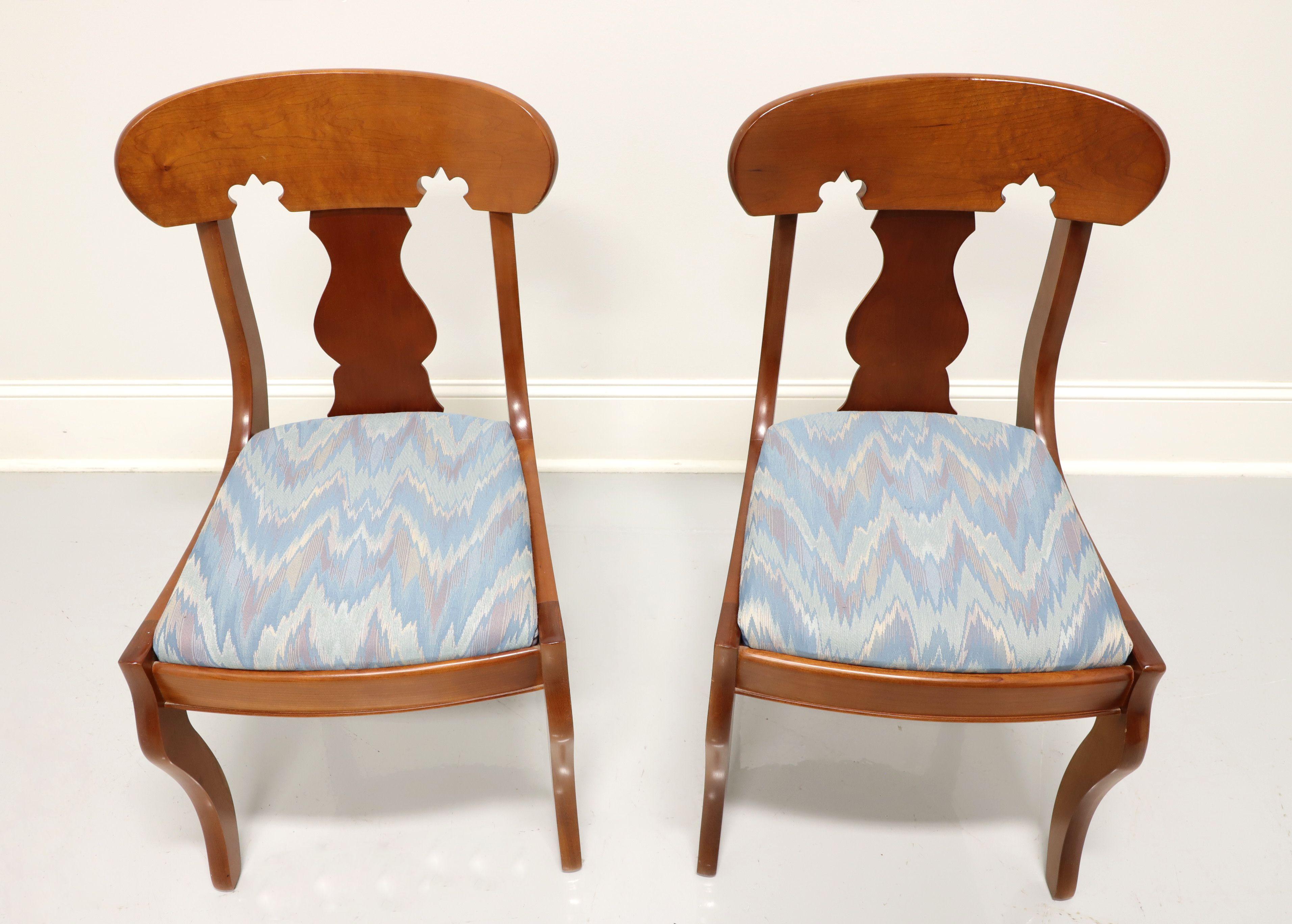 A pair of dining side chairs in the Empire style by Cassady Furniture. Solid cherry with baluster seatback, curved top, arching side rails aligning with the seat and gently curved legs. Upholstered seat in flame pattern fabric. Made in Kentucky,