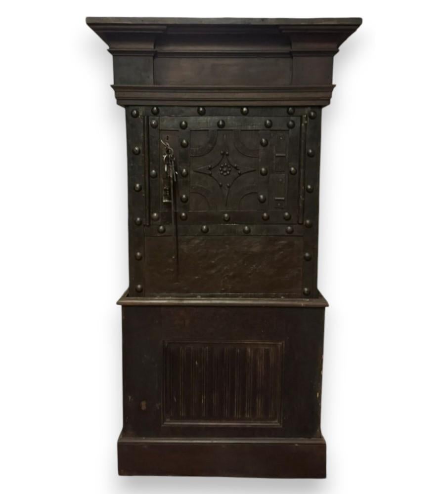 Antique safe made of walnut wood, lined with iron and decorated with studs.
Front with door decorated with geometric elements and central flower.
Features door lock mechanism. Keys present. 
The interior has document compartments and five drawers.