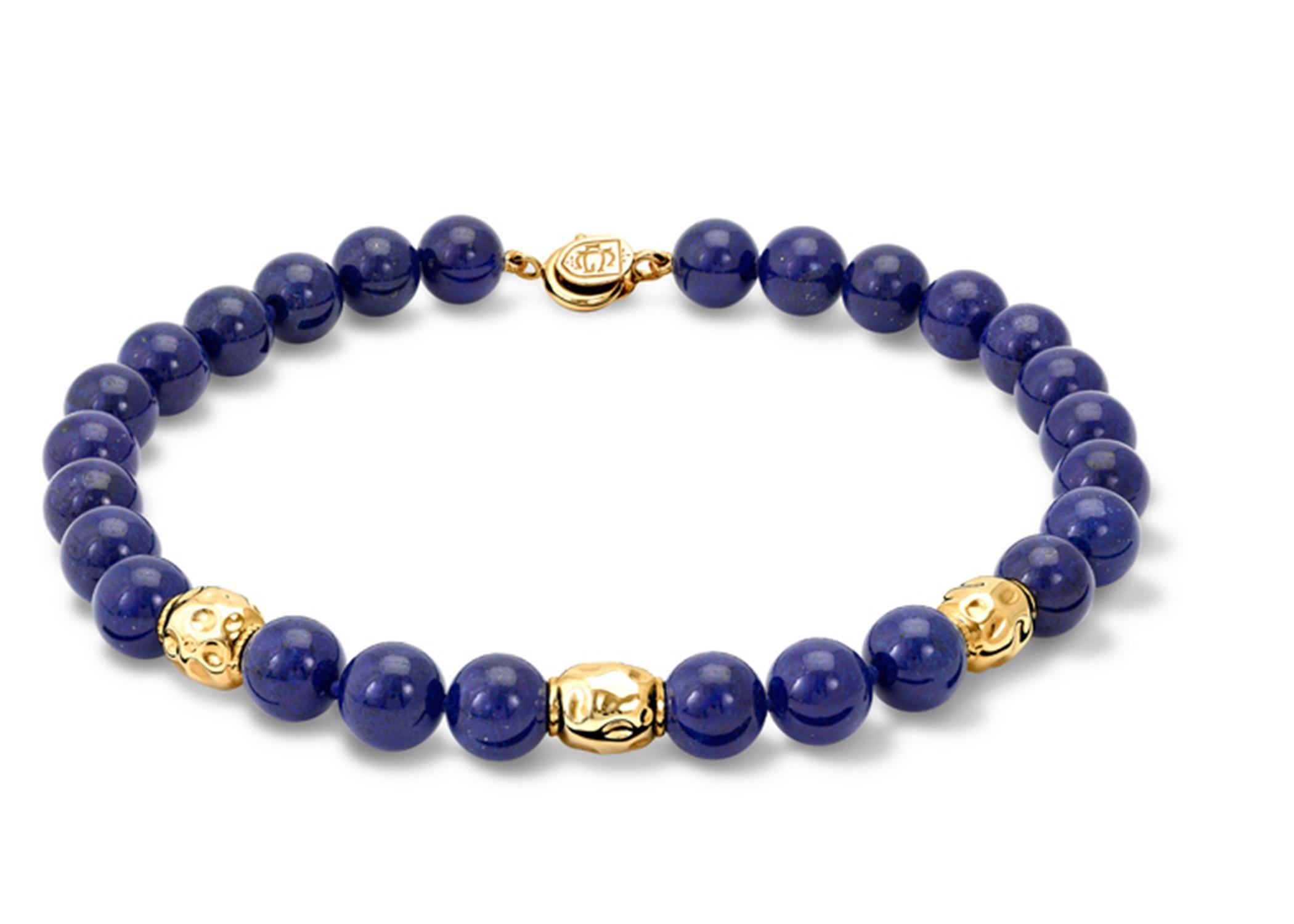 Astarte necklace of 12 mm Lapis Lazuli beads strung knotted with three Astarte spacers in 9 carat yellow gold in the form of a beaten gold bead and with a 9 carat yellow gold Lowe clasp. Astarte was the Phoenician Goddess, known to the Greeks as